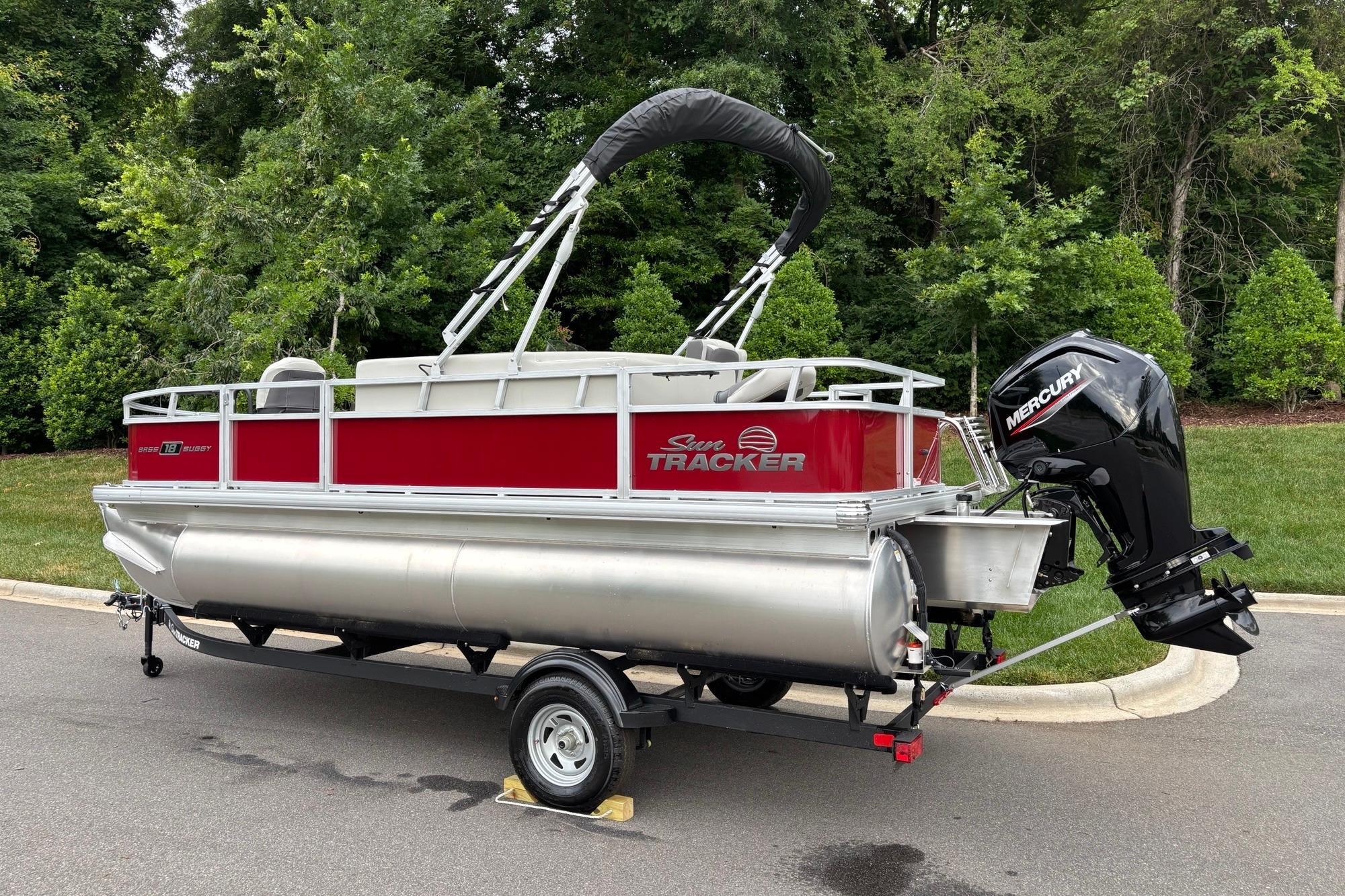 2026 Sun Tracker Bass Buggy 18 DLX pontoon boat with Mercury outboard motor on trailer.