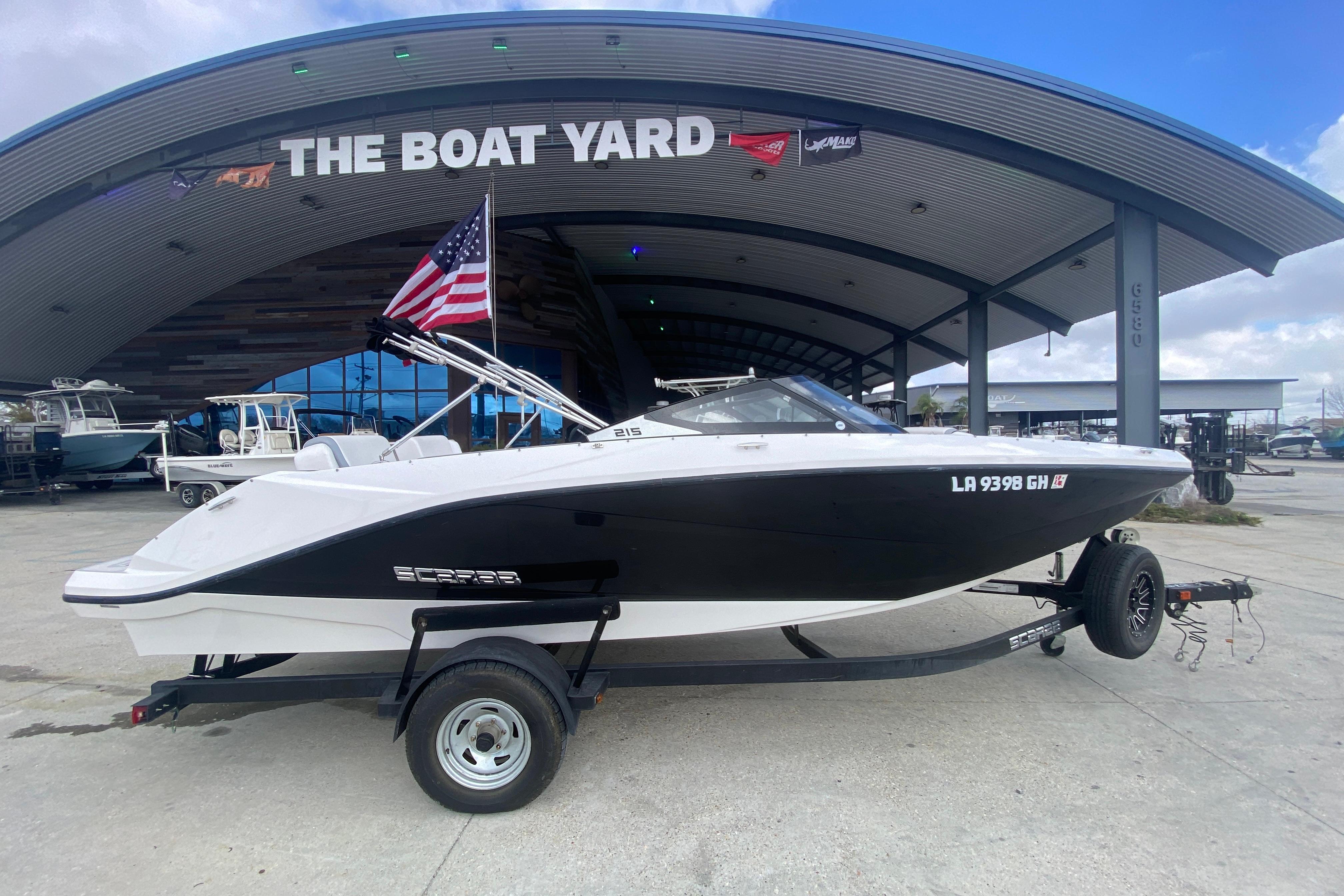 2018 Scarab 215 G boat on trailer at The Boat Yard, American flag displayed.
