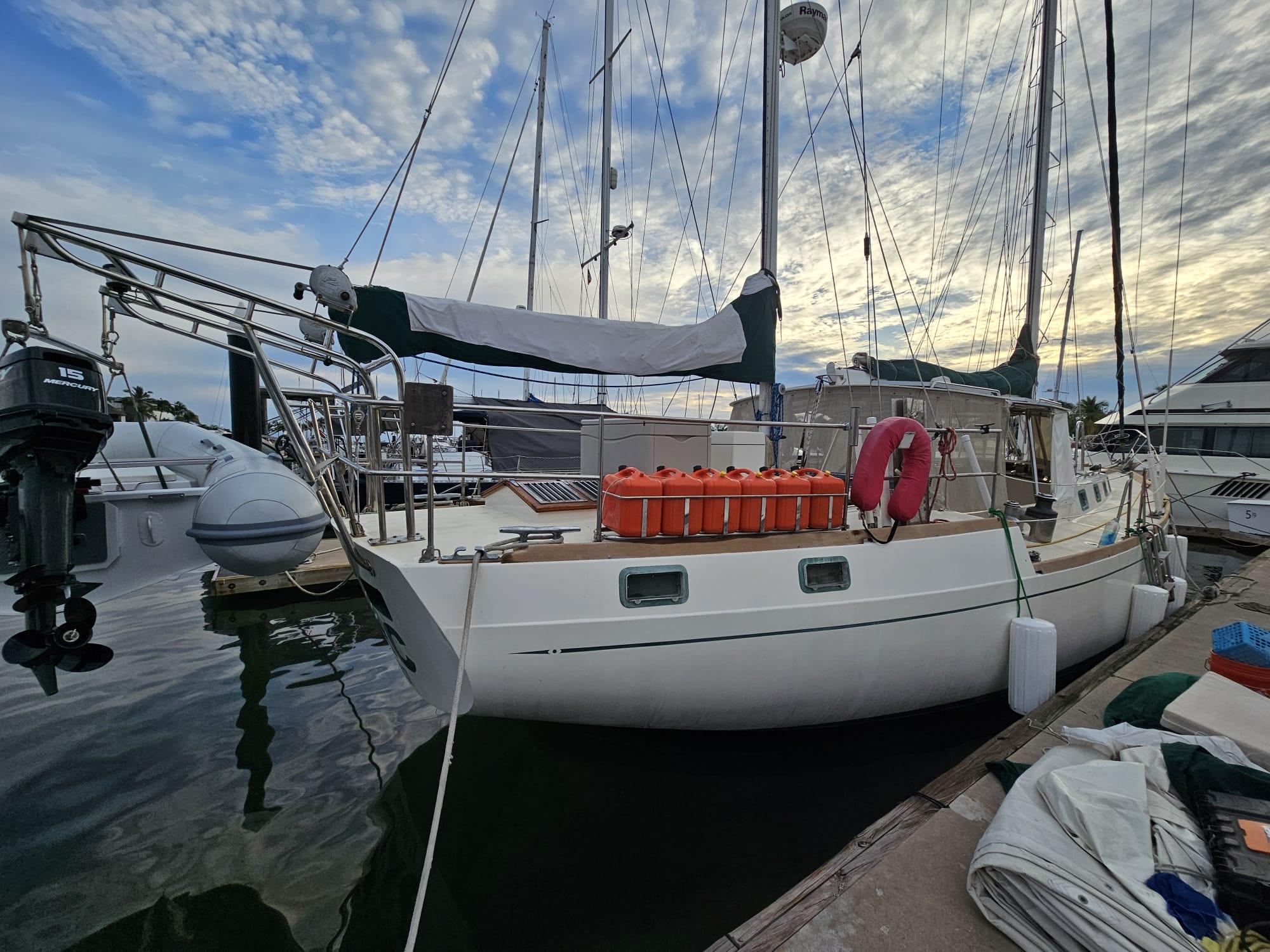 1978 Herreshoff 50 sailboat docked at marina under cloudy sky.