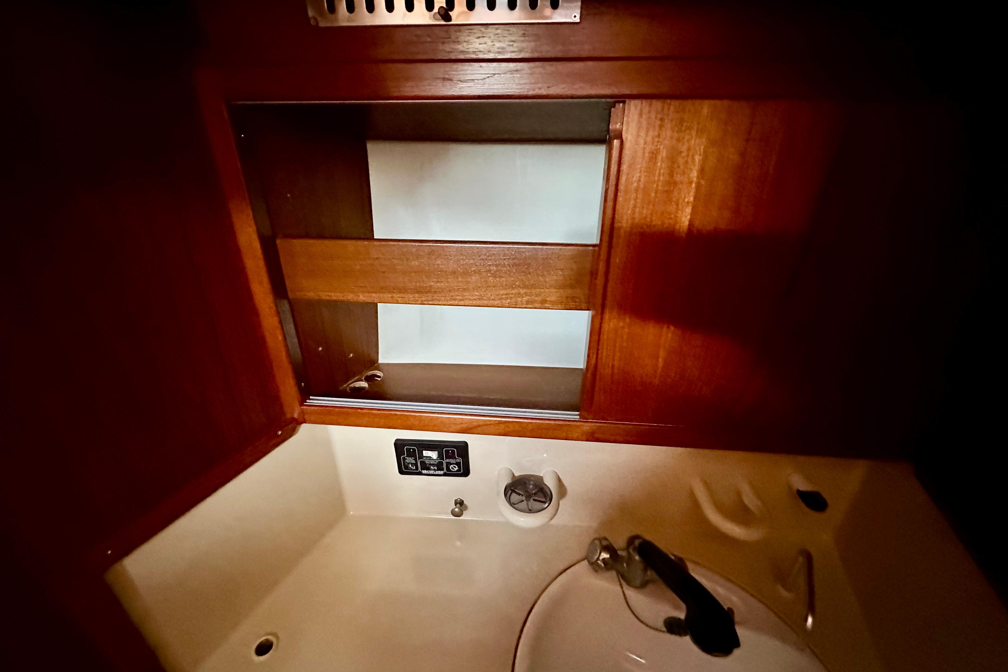 Interior of 1984 Jonmeri 40 sailboat with wooden cabinetry and sink.