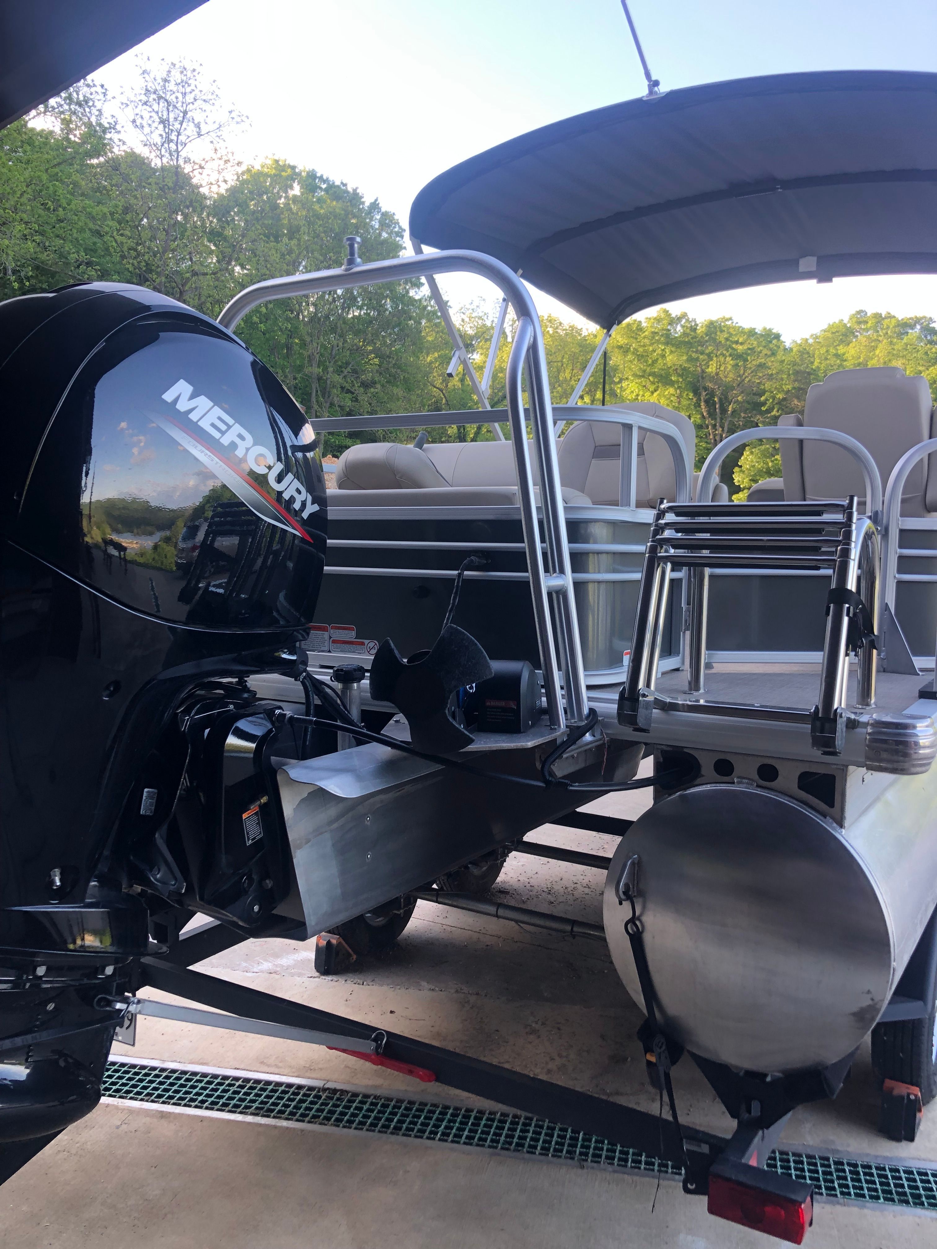 A 2023 Sun Tracker Fishin' Barge 22 DLX with a Mercury outboard motor, on a trailer.