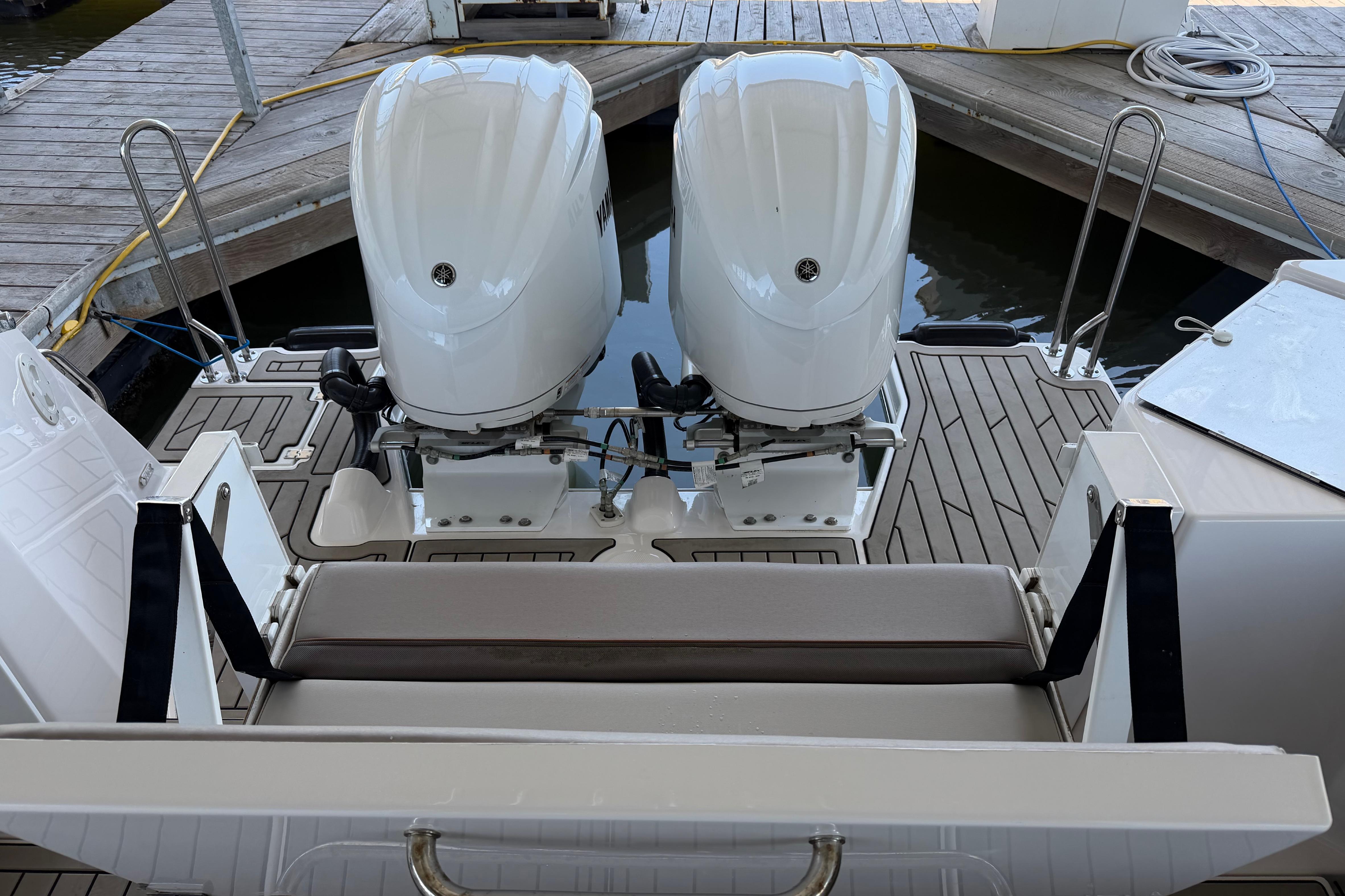 2023 Cutwater C-288 Coupe with dual outboard engines on a wooden dock.