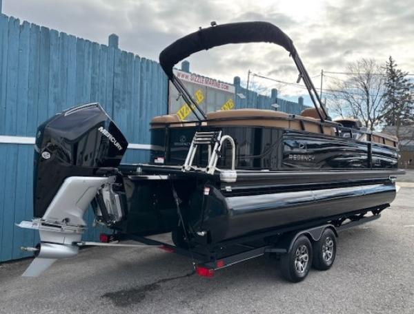 2025 Regency 230 LE3 pontoon boat on trailer, featuring sleek black design and powerful Mercury outboard.