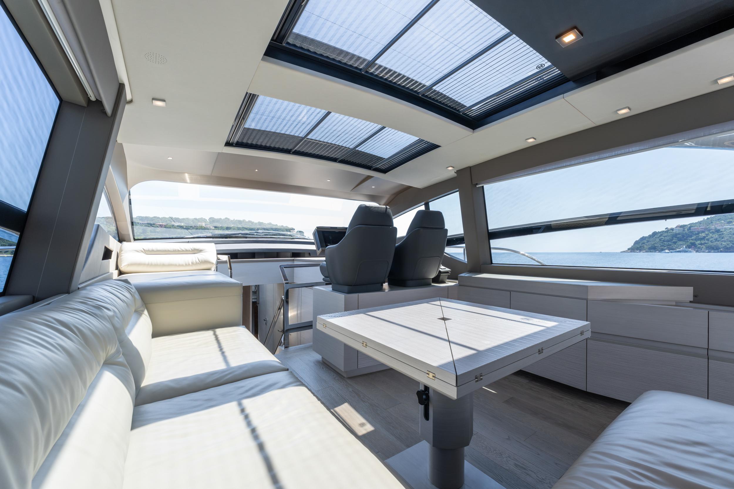 Luxurious interior of 2024 Pershing 7X yacht with panoramic windows and modern seating.