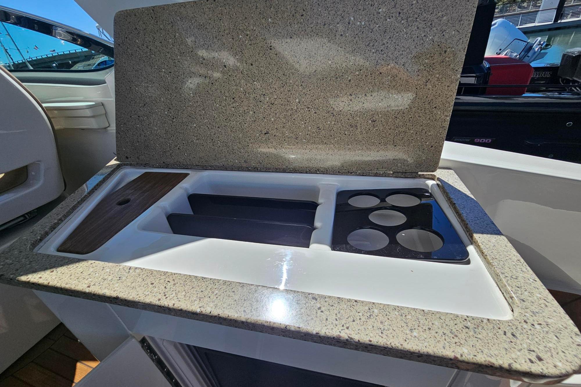 2016 Sea Ray Sundancer 350 boat kitchenette with granite countertop and integrated cup holders.