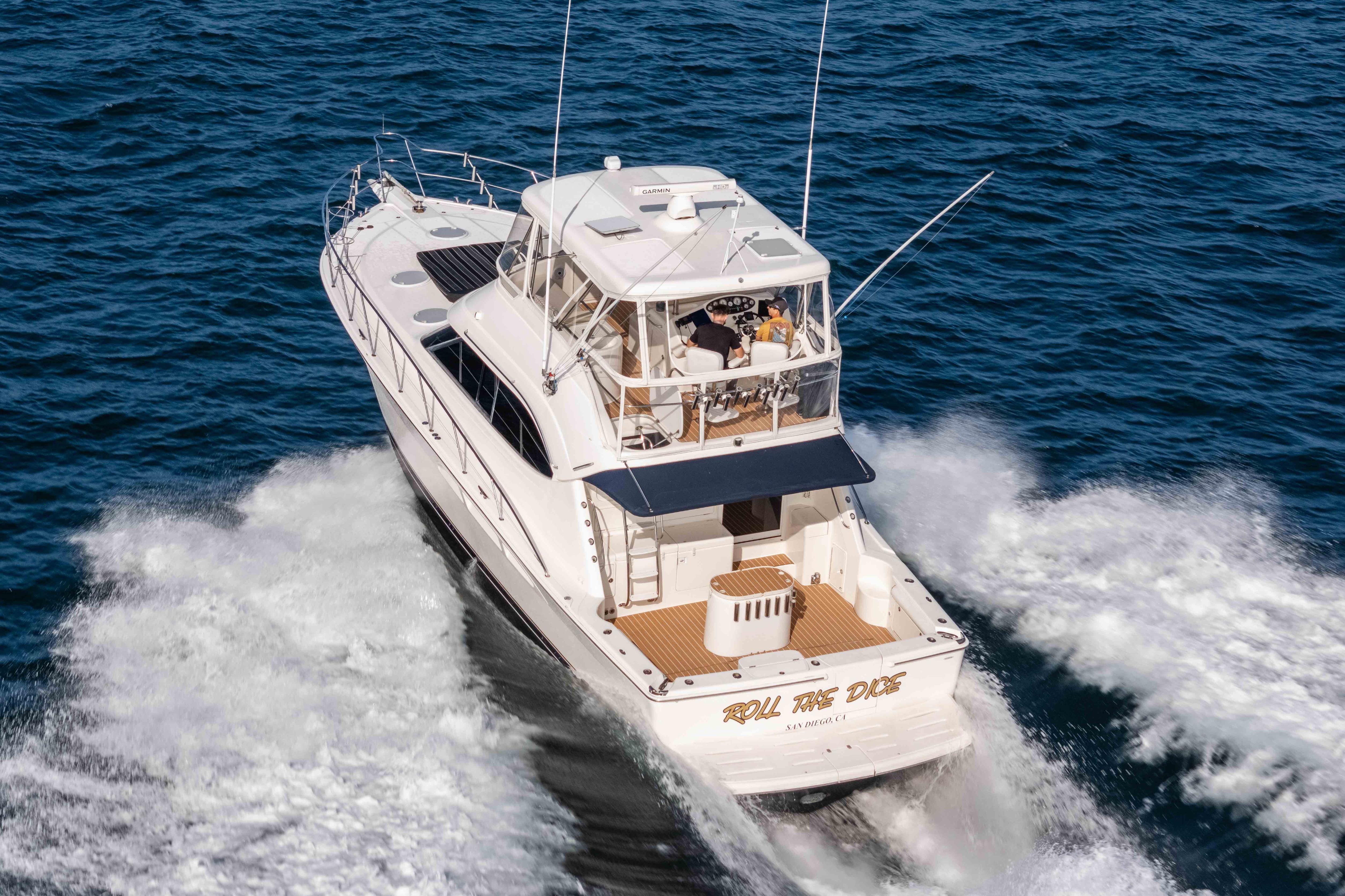 2005 Riviera 47 Convertible yacht cruising on open water, rear view.