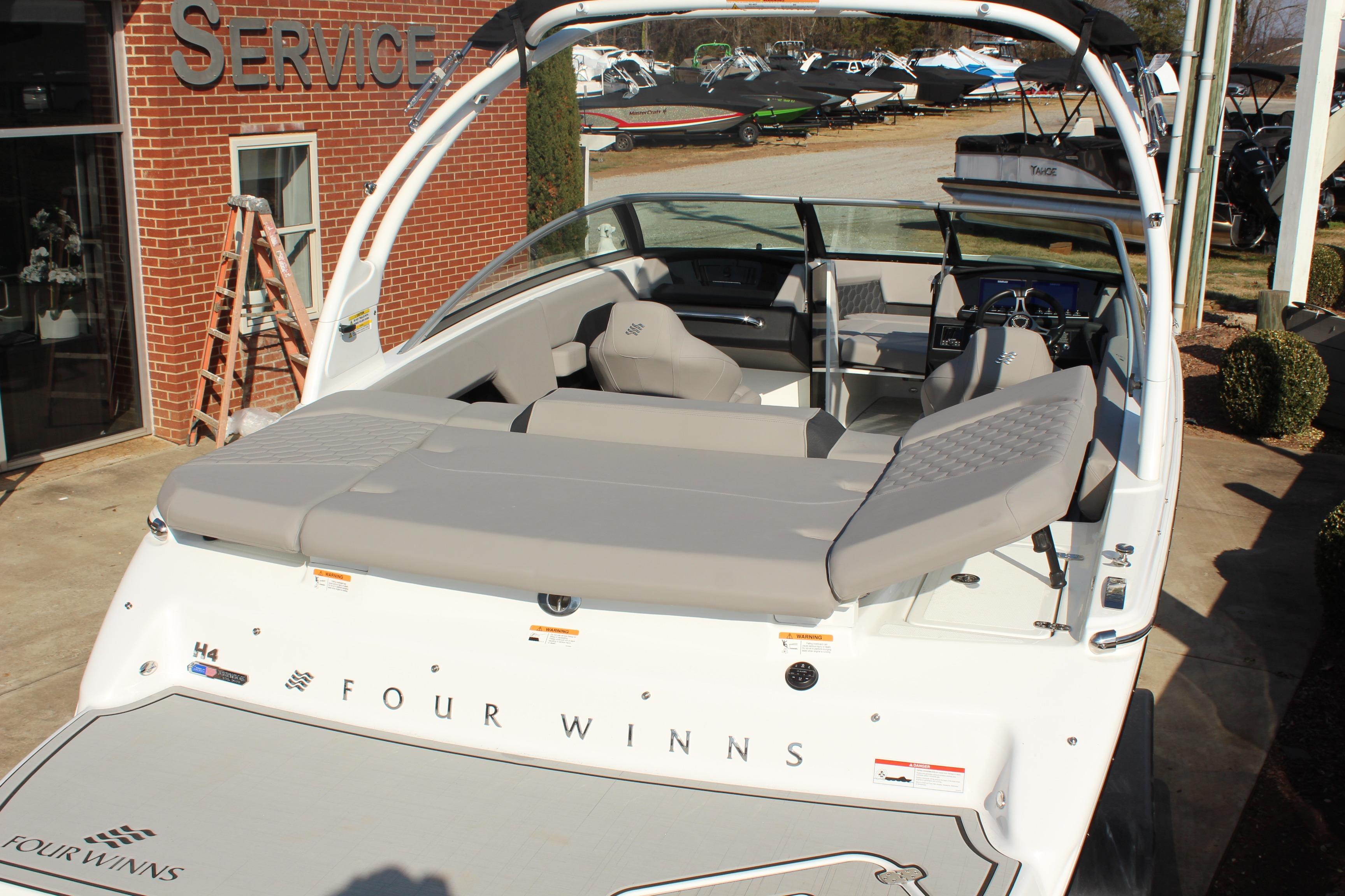 2026 Four Winns H4 boat with sleek design, displayed outdoors near service center.