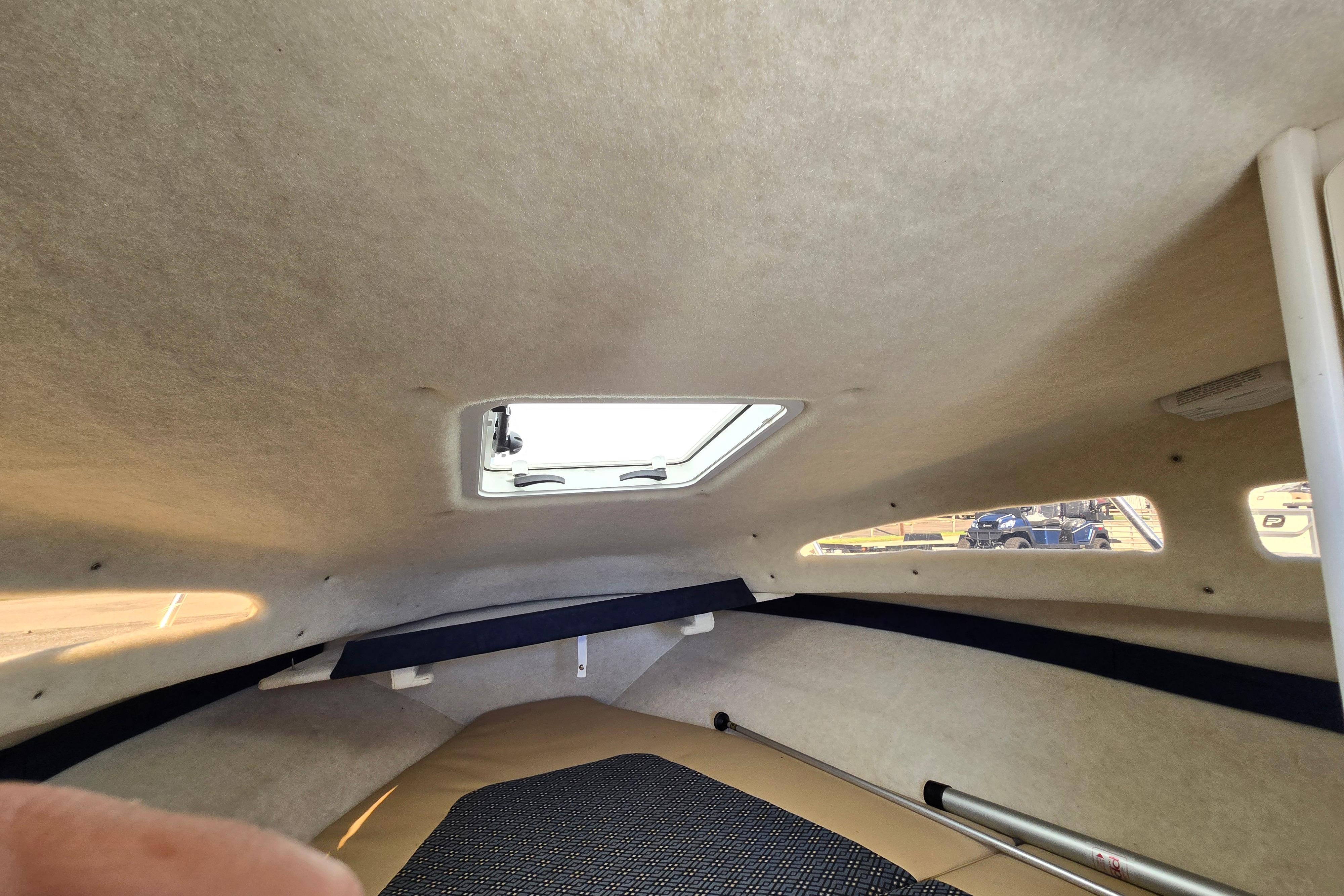Interior cabin of 2006 Bayliner 222 Classic boat with skylight and windows.
