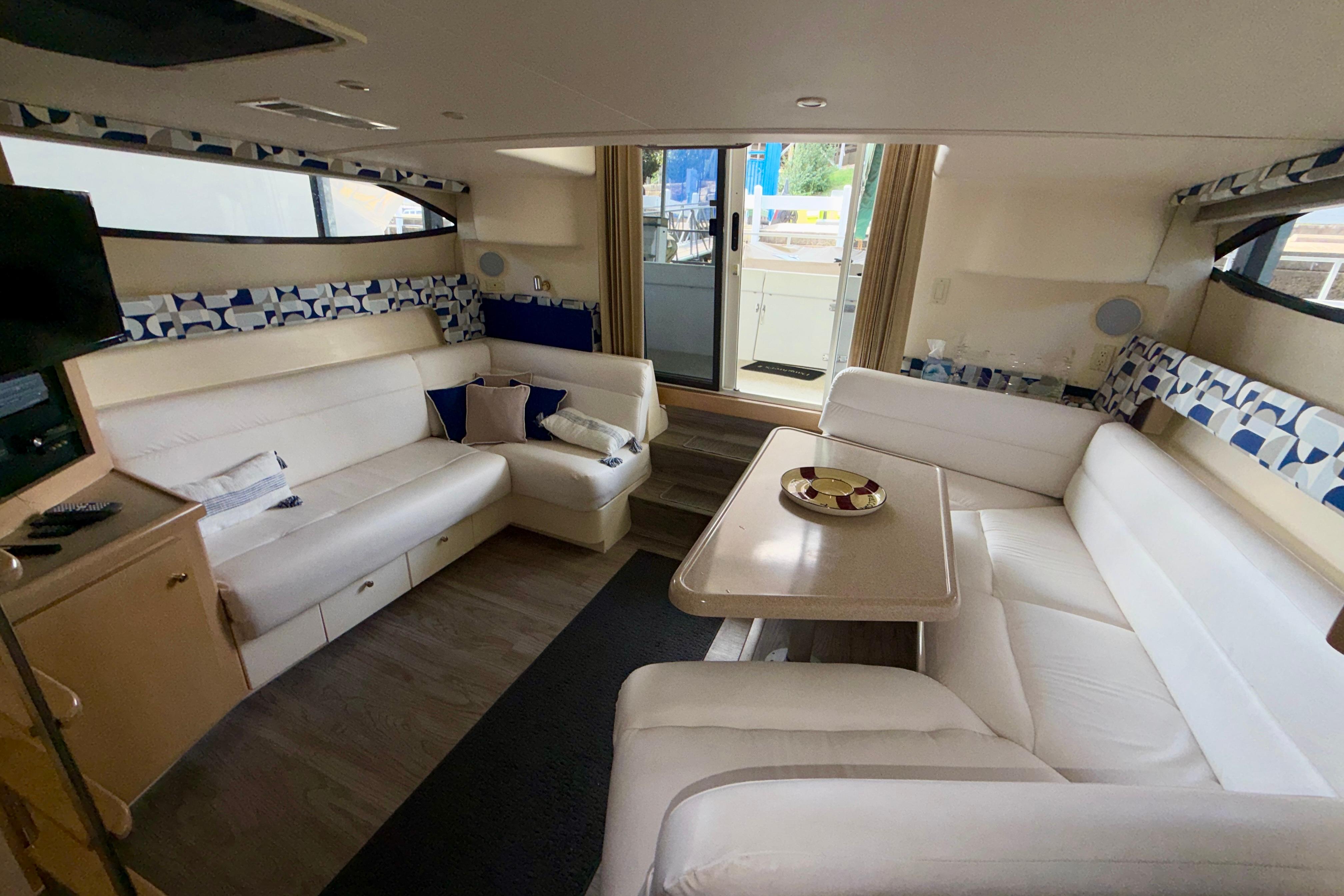Interior of 2000 Carver 350 Mariner yacht with white seating and dining table.