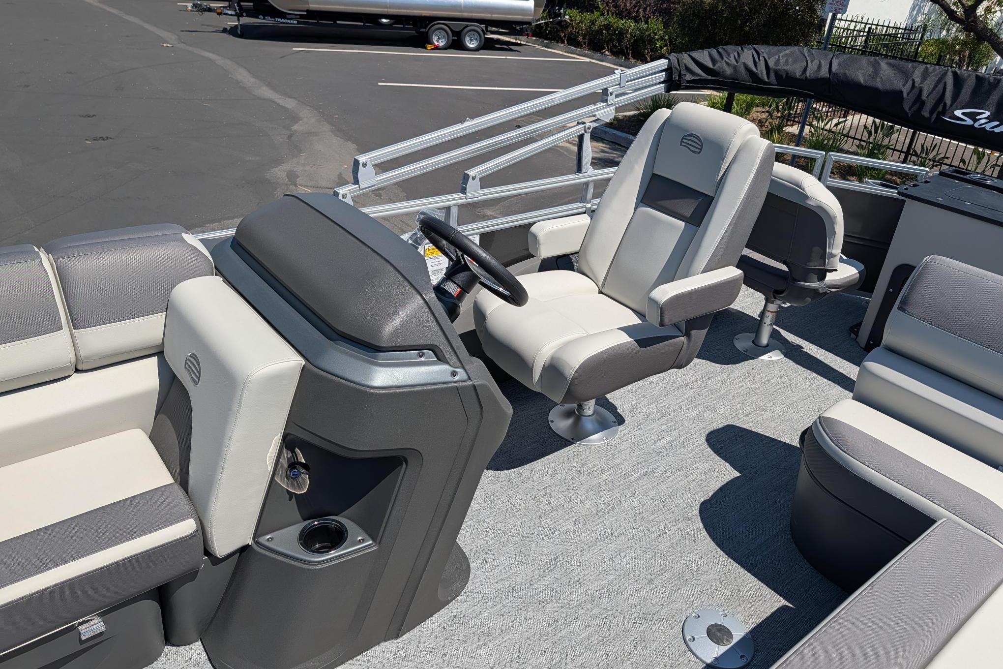 2026 Sun Tracker Fishin' Barge 22 DLX interior with comfortable seating and steering console.