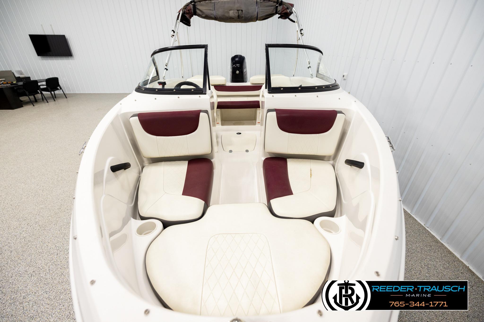 2016 Tahoe 450 TS boat interior with white and maroon seating in showroom.