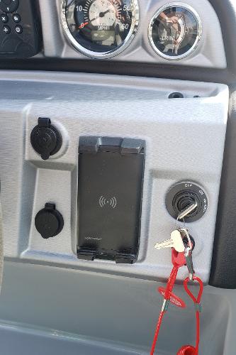 Dashboard of 2023 South Bay S224RS25 boat with keys and charger.