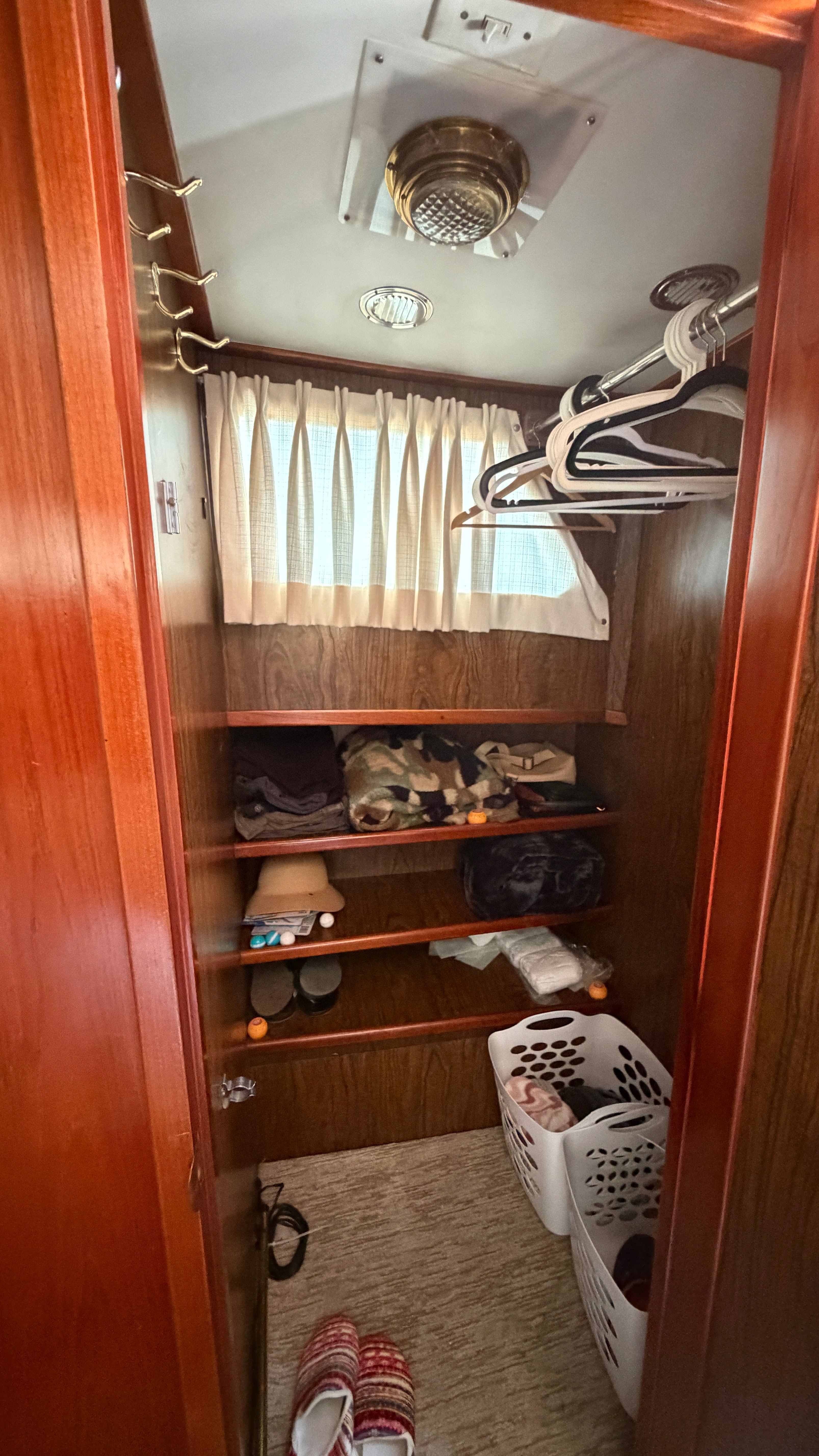 Interior of 1966 Drake Yachtfisher with wooden shelves and laundry baskets.