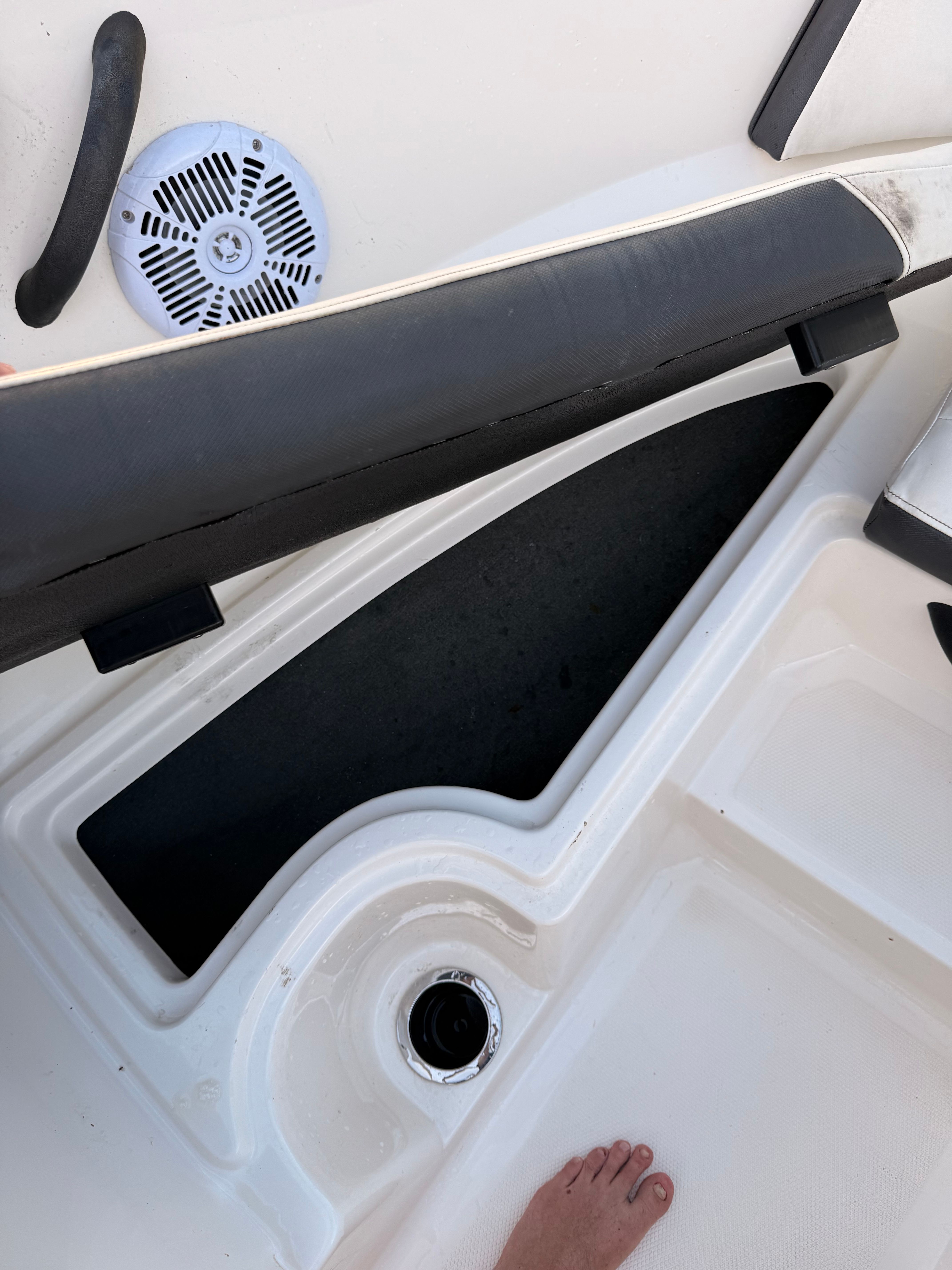 Close-up of a boat deck with a speaker and black padding.