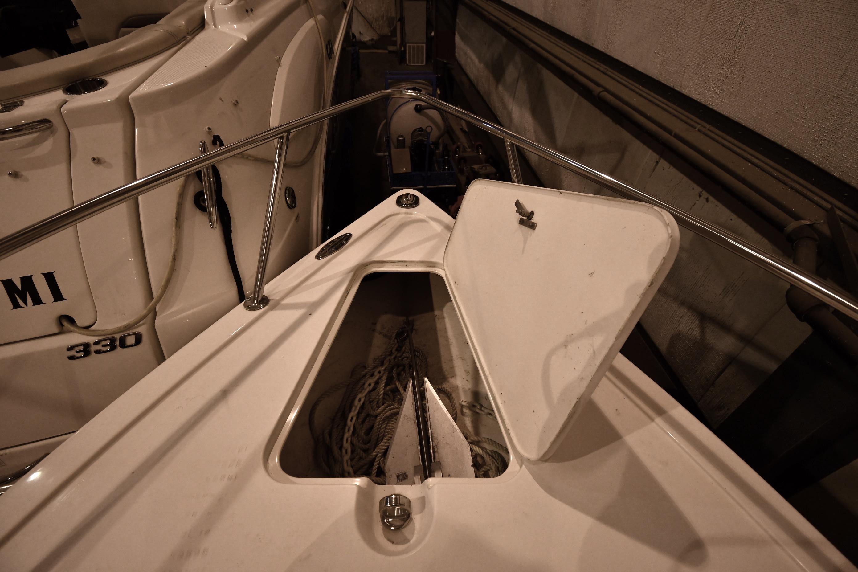 2001 Fountain 38 Center Console boat with open storage compartment, docked beside another vessel.