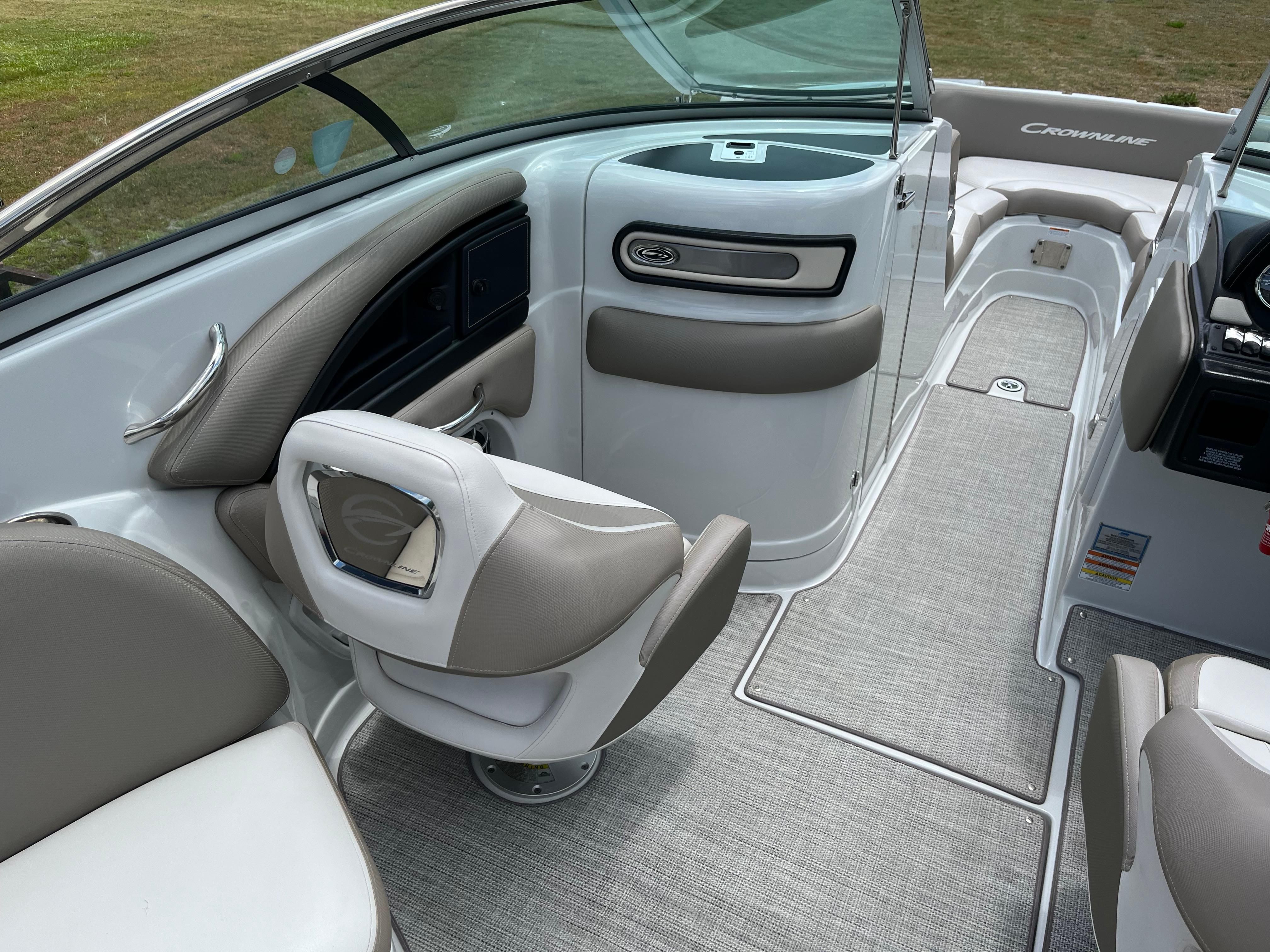 The image shows the cockpit of a 2019 Crownline E 285 boat with gray carpeting.