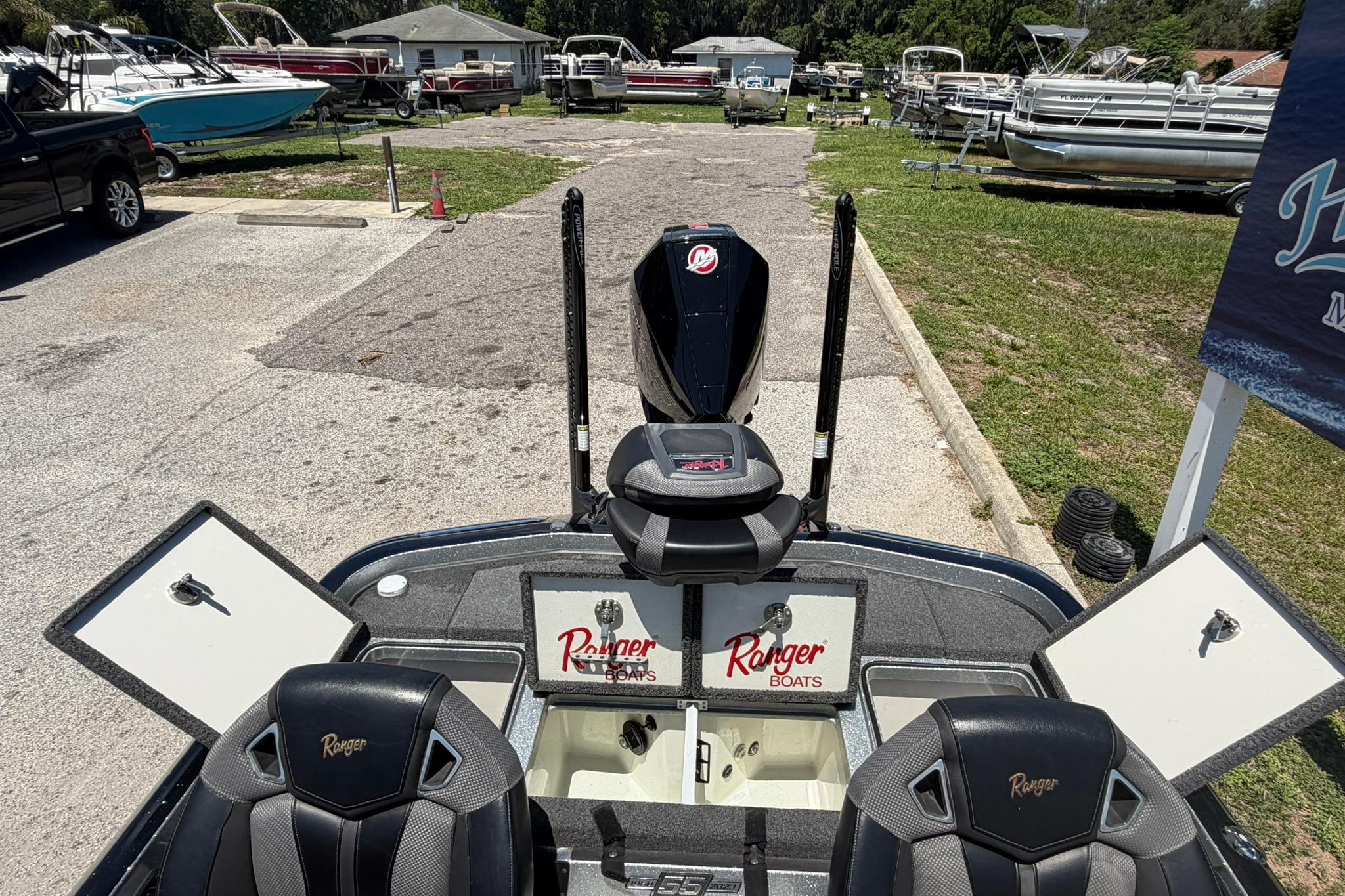 2023 Ranger Z521R boat interior with open storage compartments and seating at a marina.