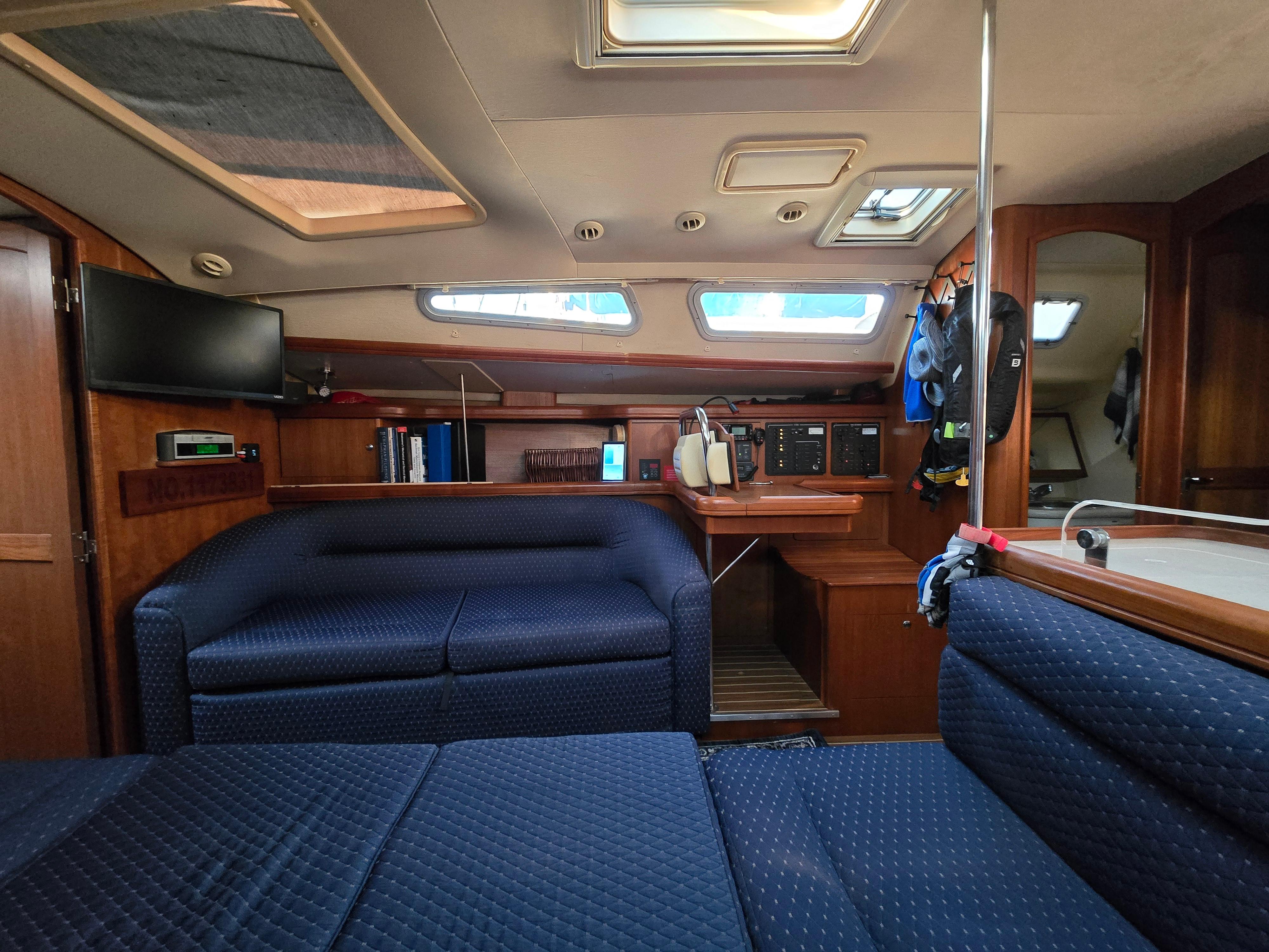 Interior of a 2004 Hunter 41 AC sailboat with blue seating and wooden accents.