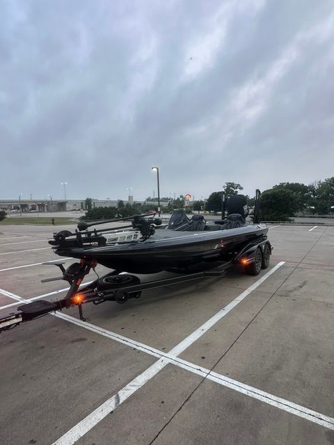 A 2023 Skeeter FXR21 Apex boat on a trailer in an empty parking lot.