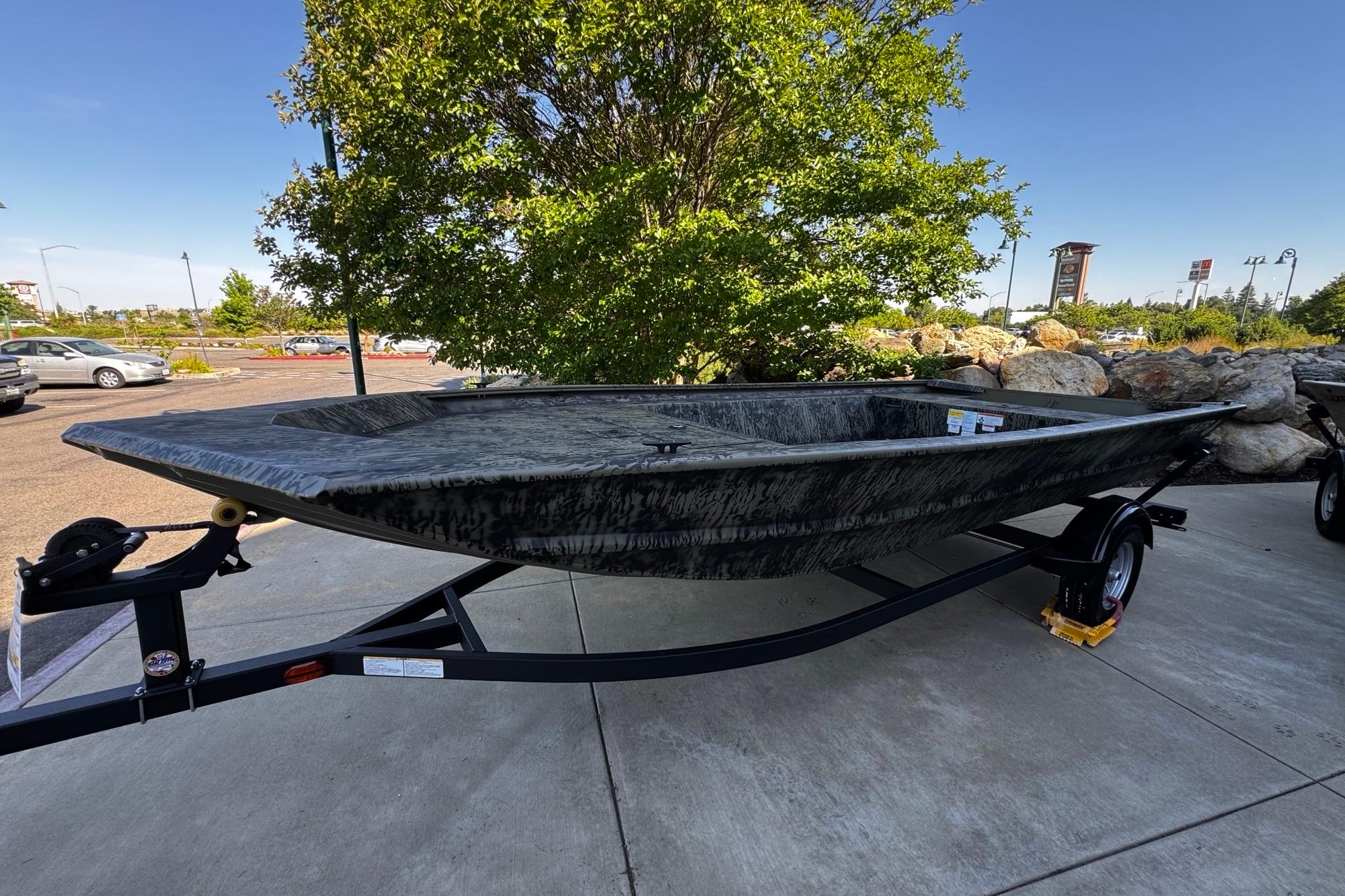 2026 Tracker Grizzly 1754 Utility boat on trailer, parked outdoors.