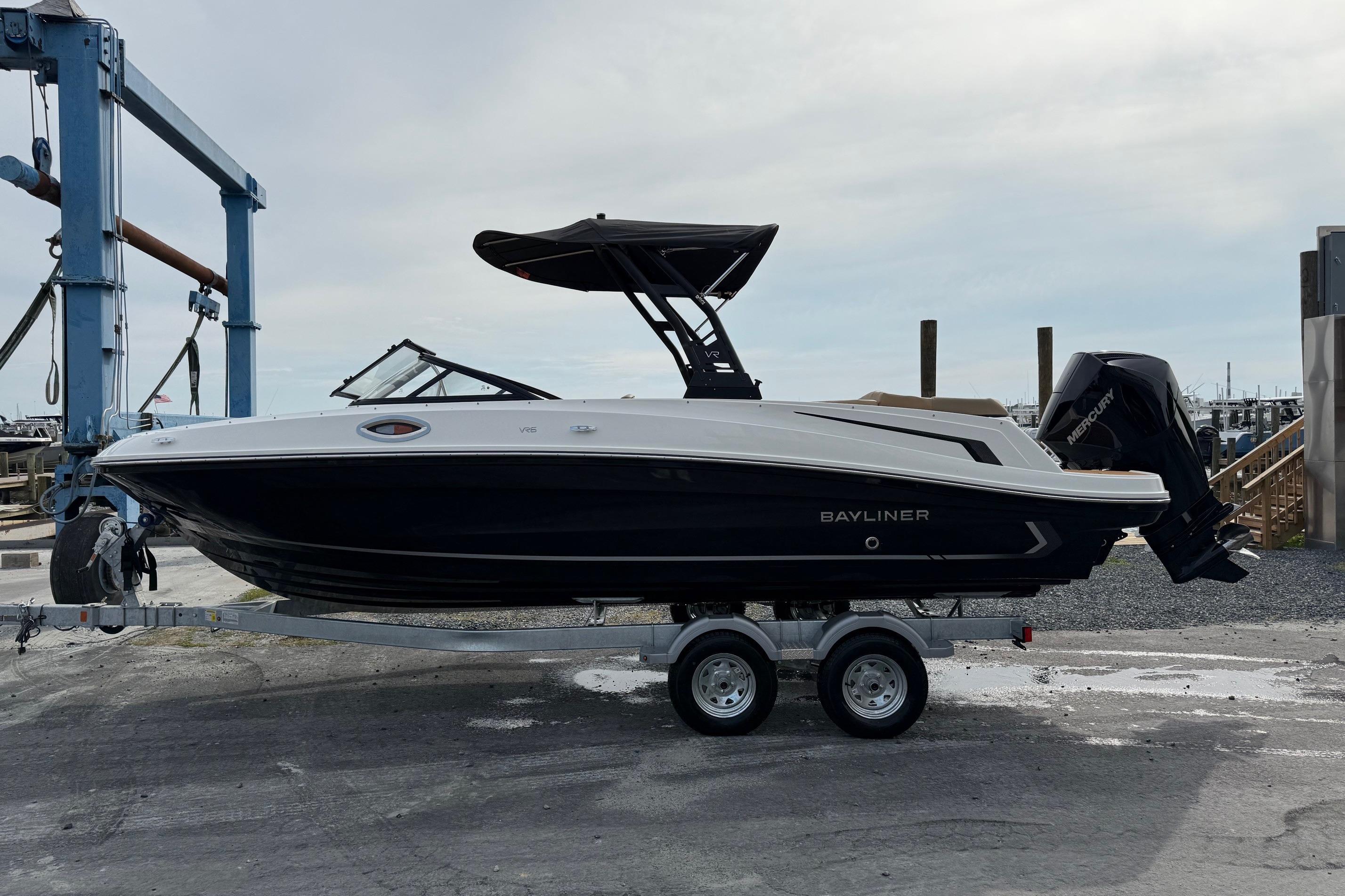 2026 Bayliner VR6 Bowrider OB on trailer at marina, side view.
