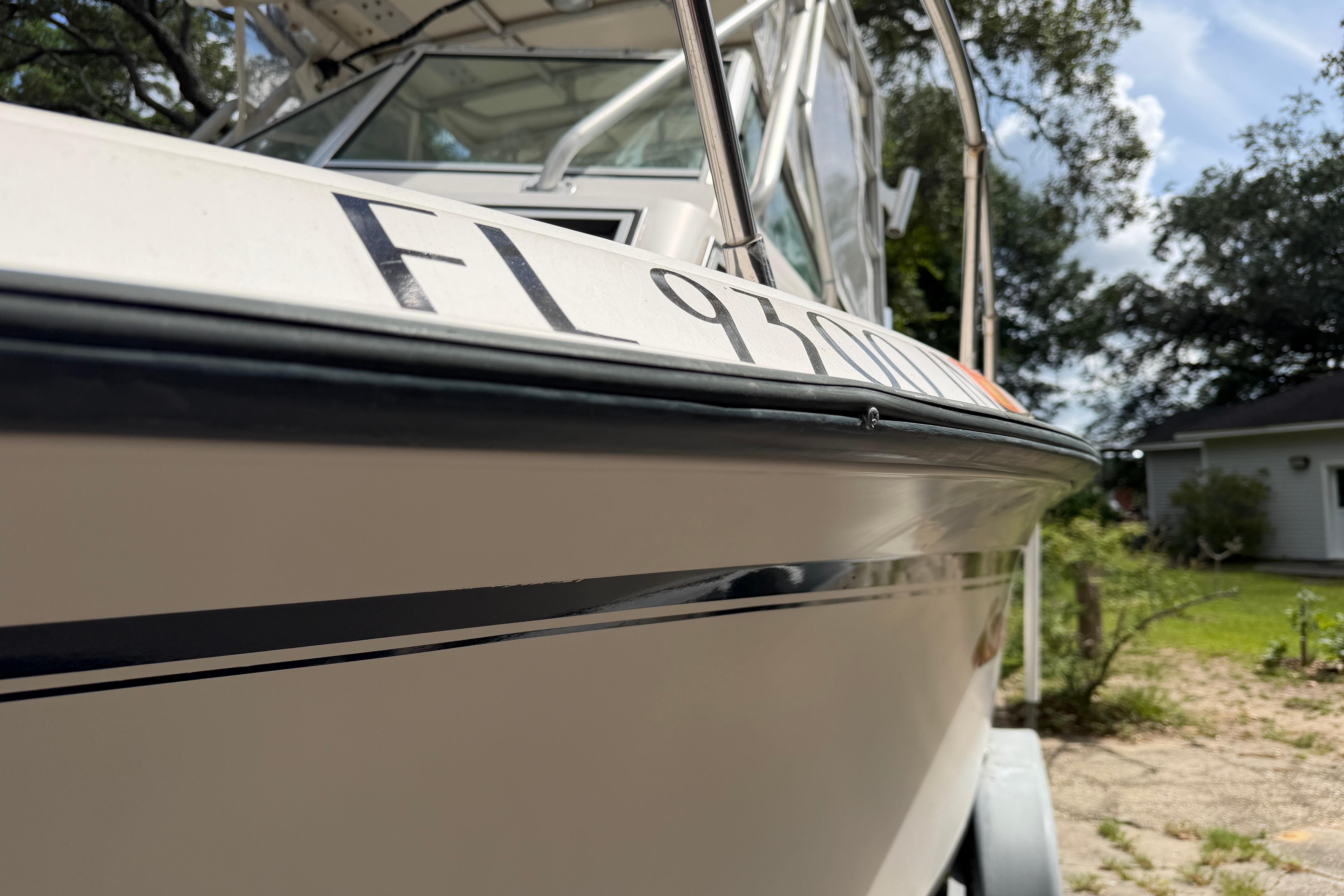 1987 Grady-White Seafarer 226 boat with registration number, parked outdoors.