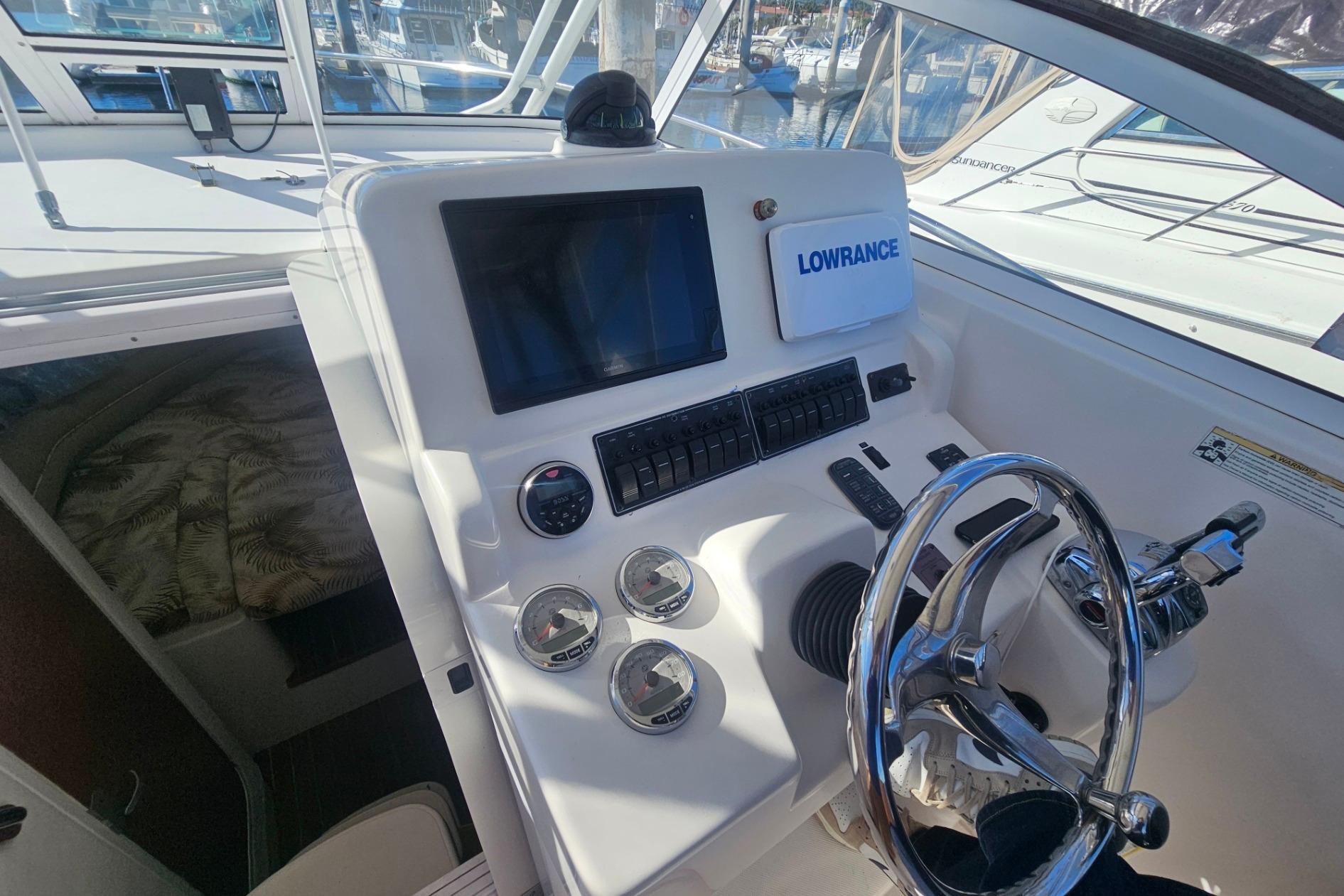 2006 Pro-Line 32 Express boat dashboard with steering wheel and navigation controls.