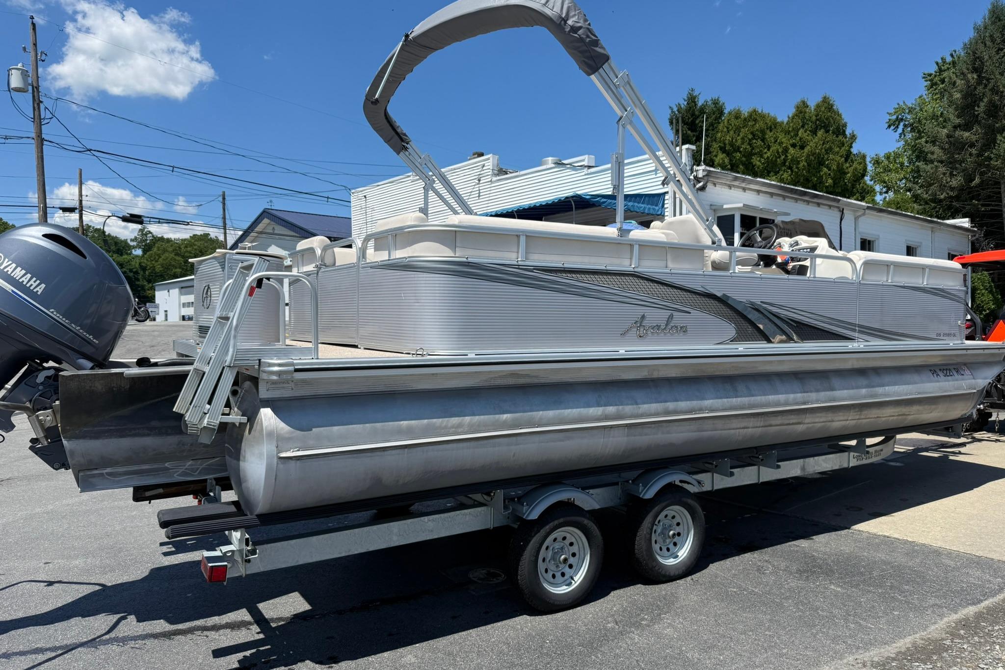 2019 Avalon GS Quad Lounge 25' pontoon boat on trailer, featuring Yamaha outboard motor.