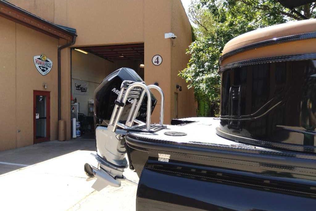 2026 Regency 230 DL boat with Mercury engine outside a workshop.