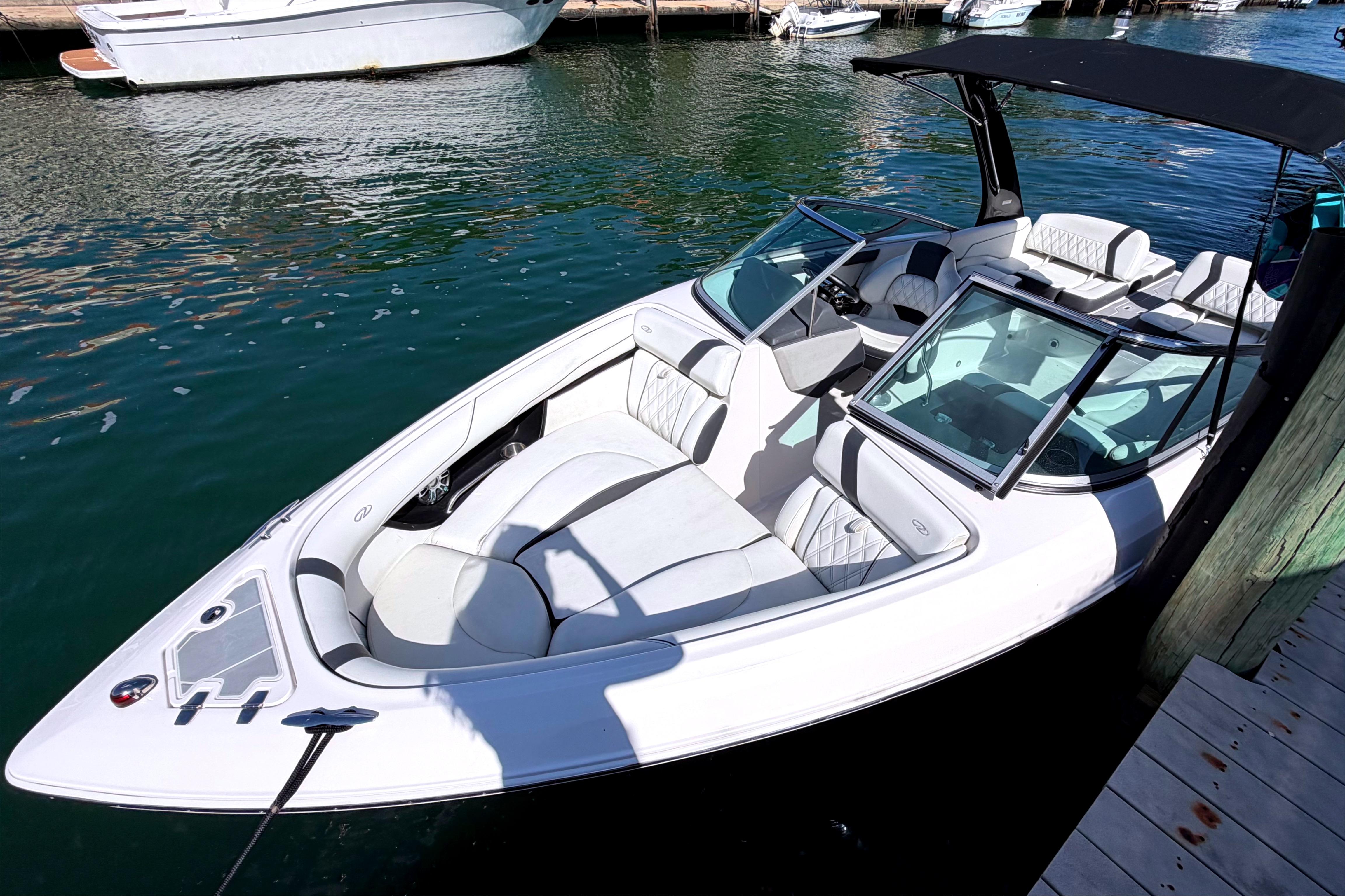 2020 Regal 2300 Bowrider boat docked in marina, featuring sleek design and spacious seating.