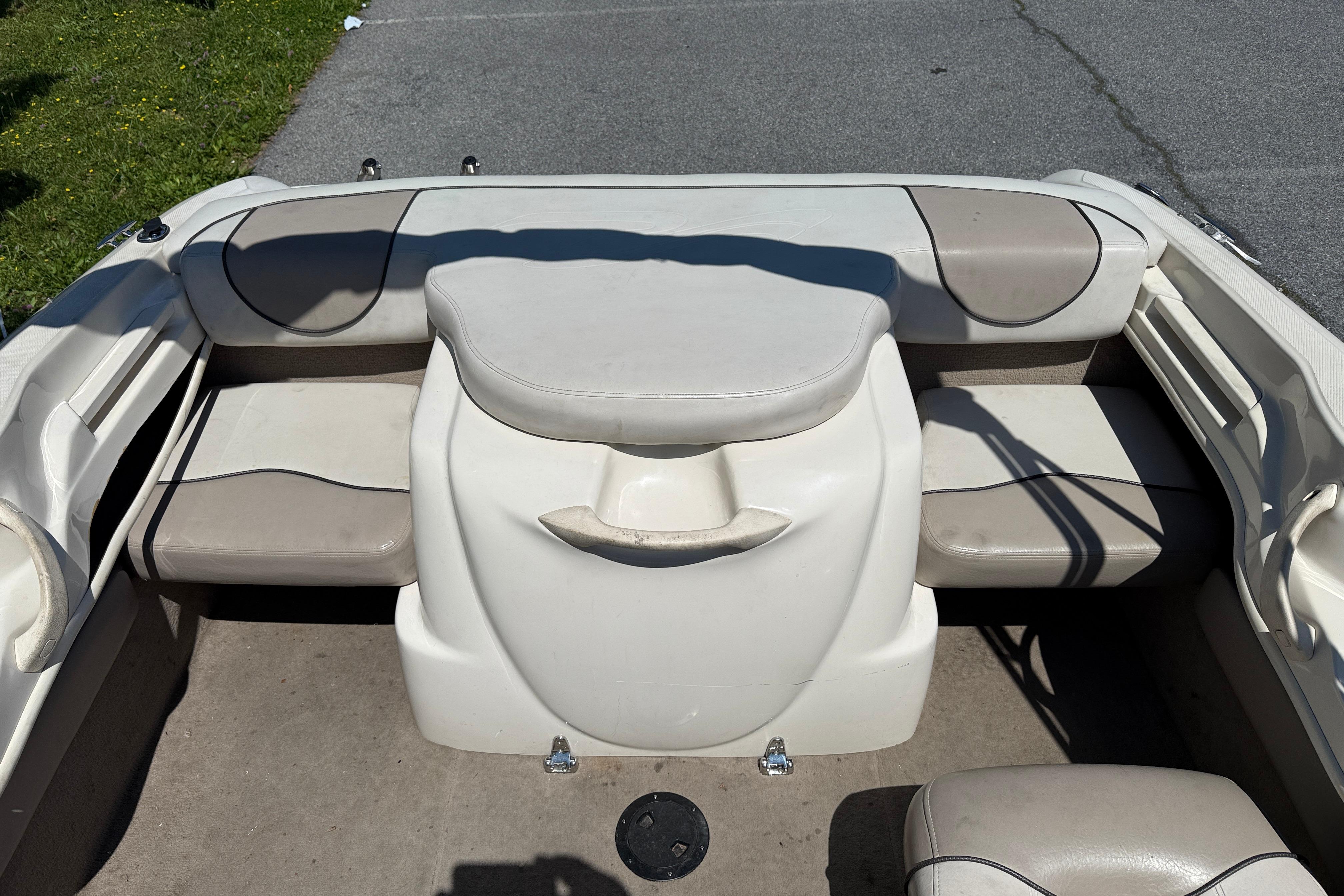 2003 Sea Ray 182 Bow Rider interior with beige seating and storage compartments.