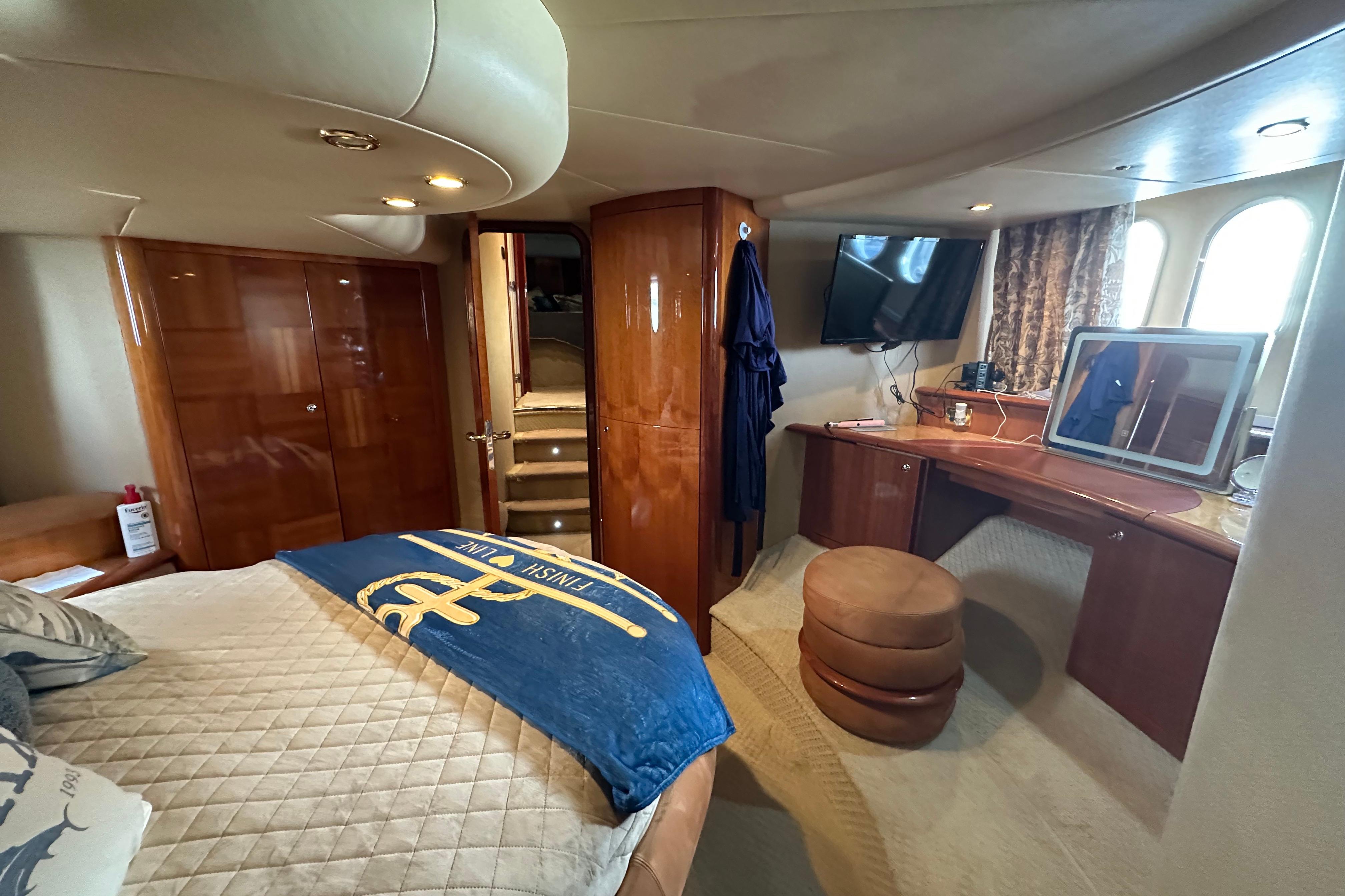 Luxurious 2004 Azimut 55E yacht bedroom with elegant wood finishes and modern amenities.