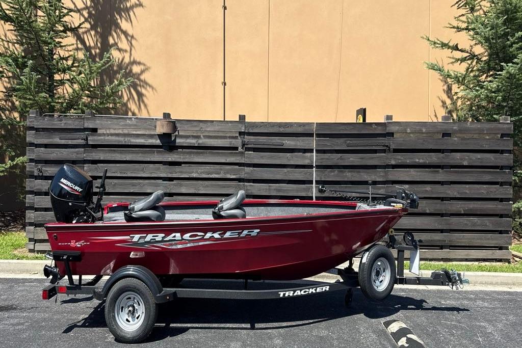 2025 Tracker Super Guide V-16 T boat on trailer, parked outdoors.