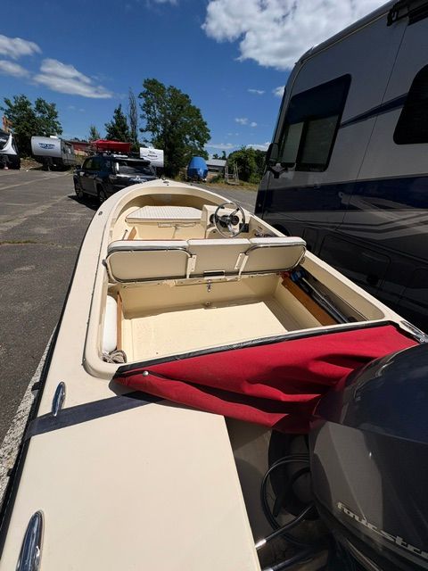 A 2014 Rossiter 14 boat is parked next to an RV in a lot.