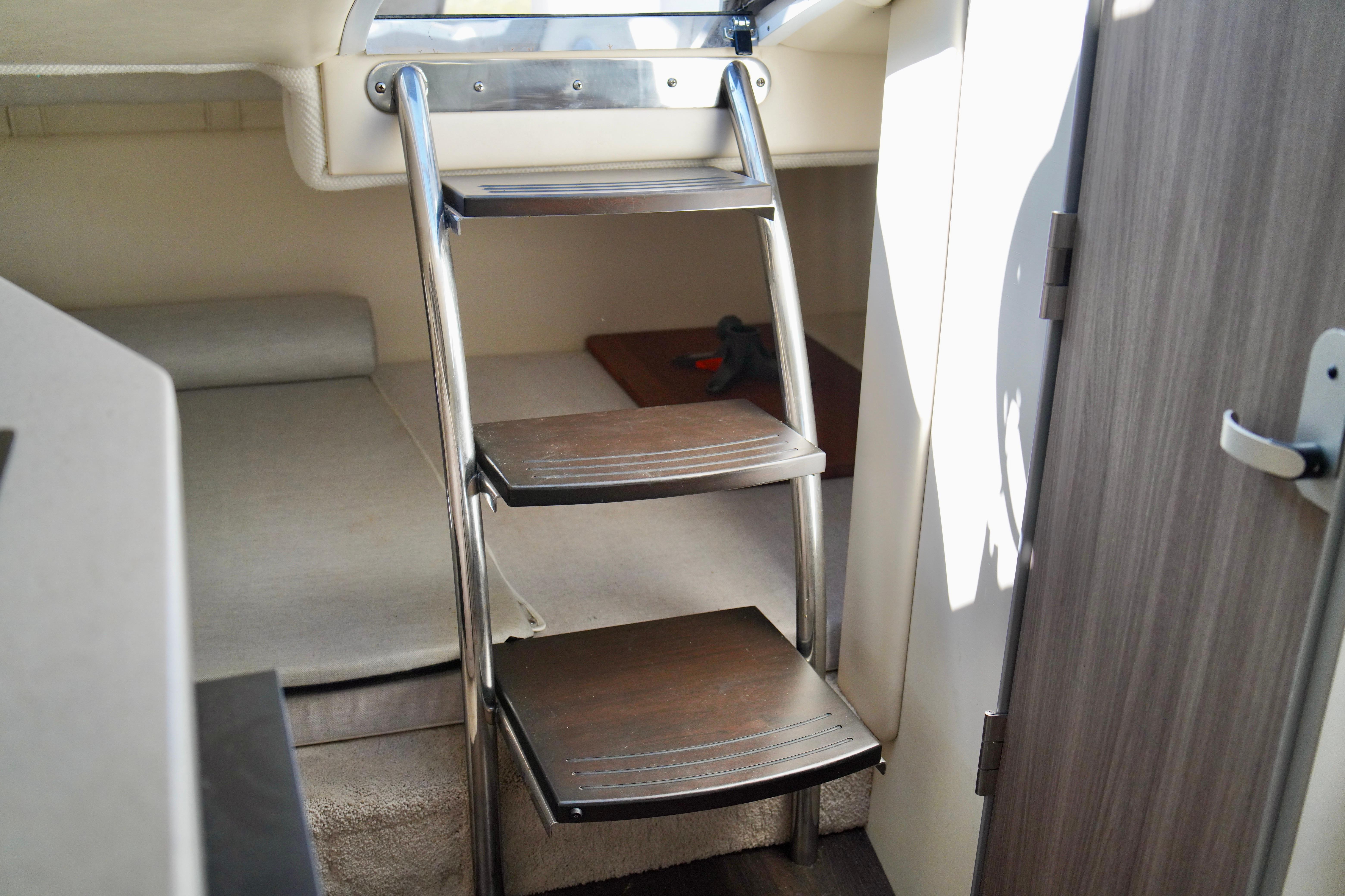 Interior of 2019 Regal 26 Express boat with compact cabin and wooden steps.
