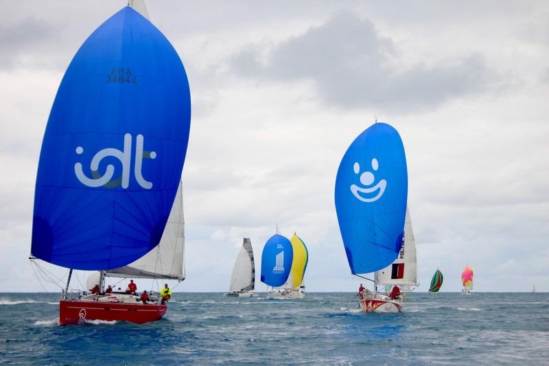 Sailboats racing with colorful spinnakers, including a 2008 Dehler 44 SQ, on a cloudy day.