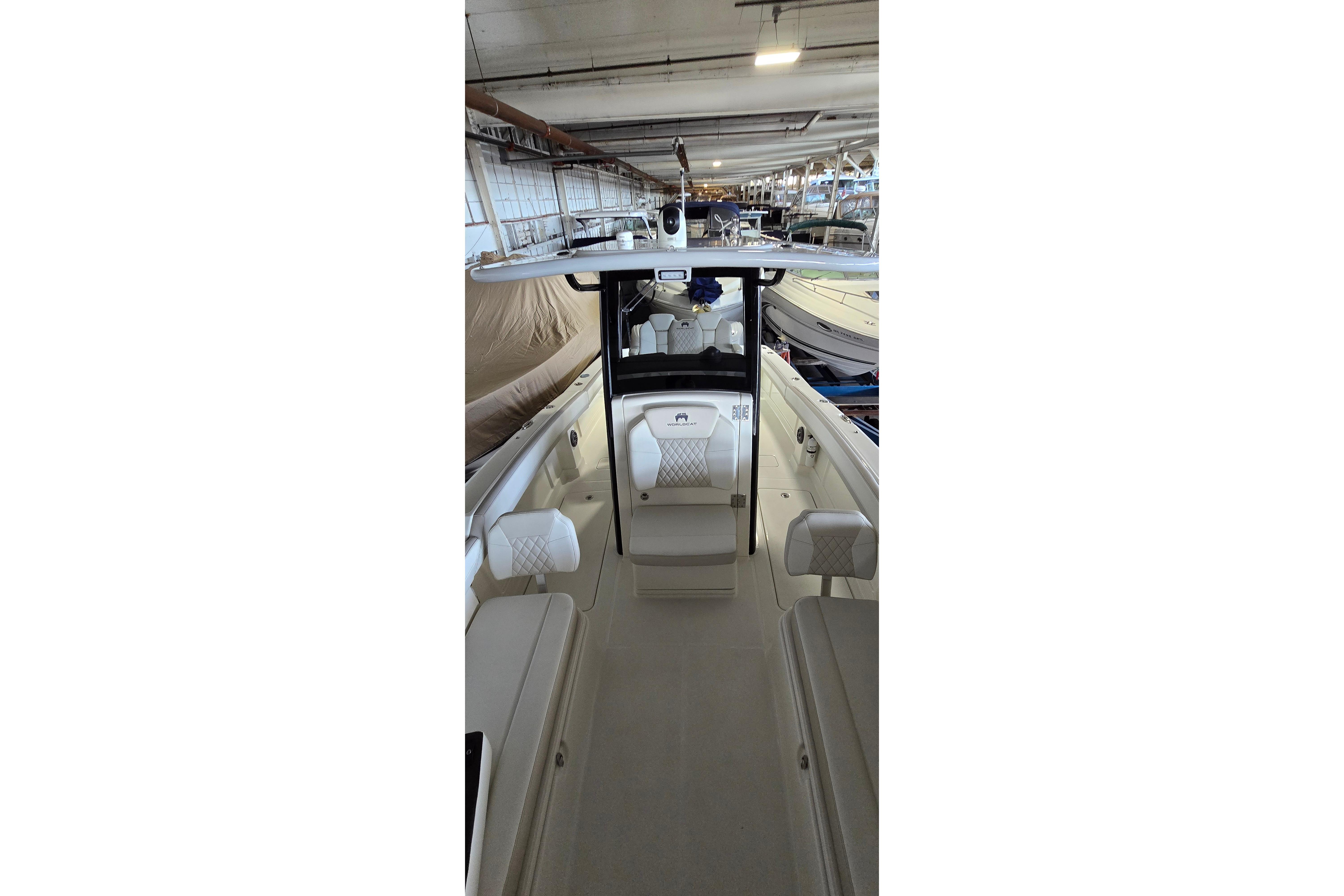 2024 WorldCat 280 CC-X boat interior with seating and helm in a storage facility.