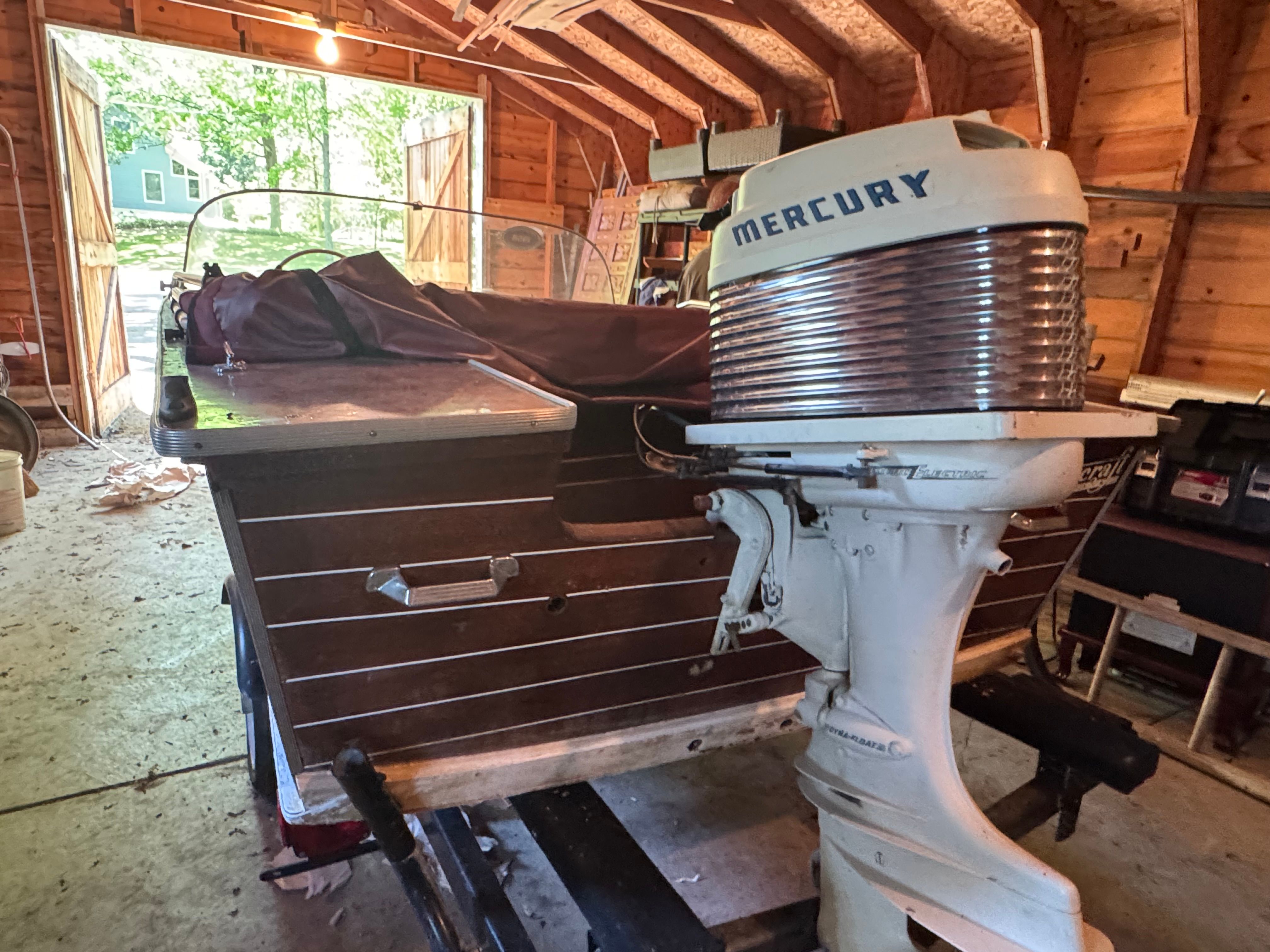 1958 Classic Sportcraft Runabout with Mercury engine in a wooden garage.