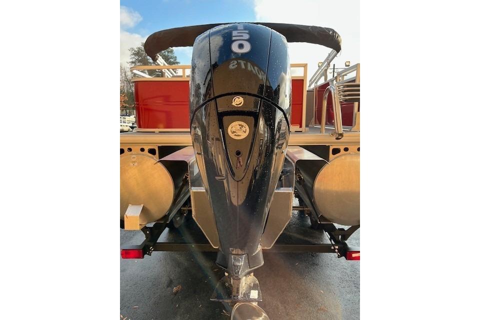 2026 Sun Tracker Party Barge 22 RF XP3 with powerful outboard motor, rear view.