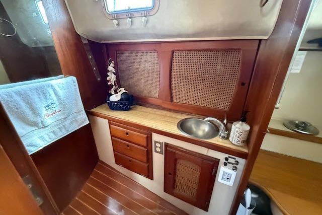 Interior of 1982 Lancer 45 Motorsailer with wooden cabinetry and compact sink area.