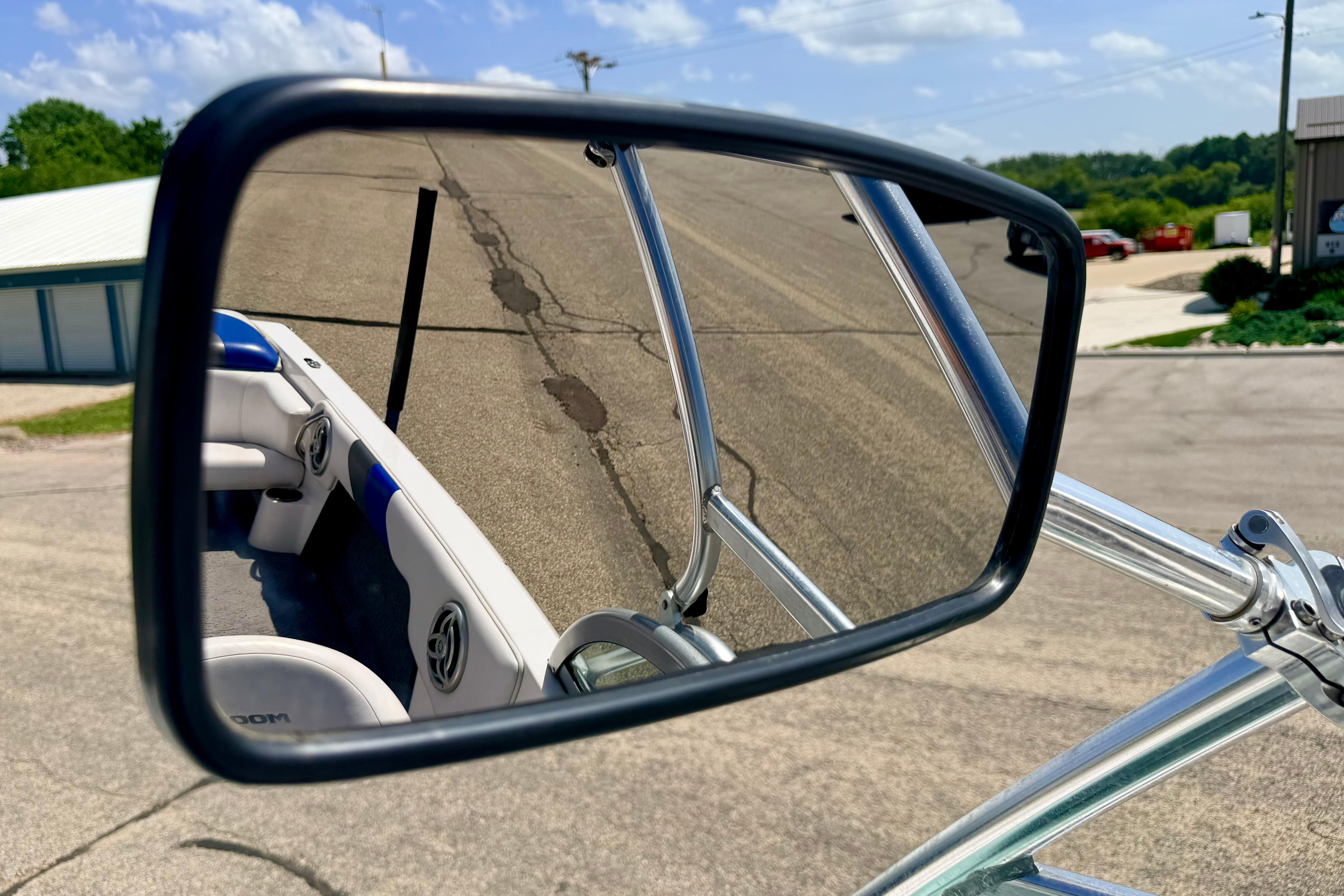 Rearview mirror reflection of a 2008 Moomba Outback V boat interior on a sunny day.