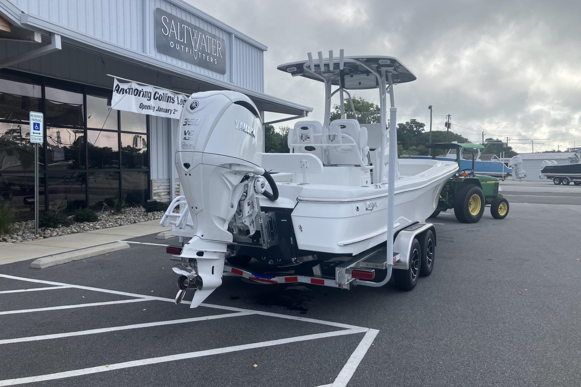 2026 BlackJack 256 Coastal boat on trailer outside Saltwater Outfitters store.