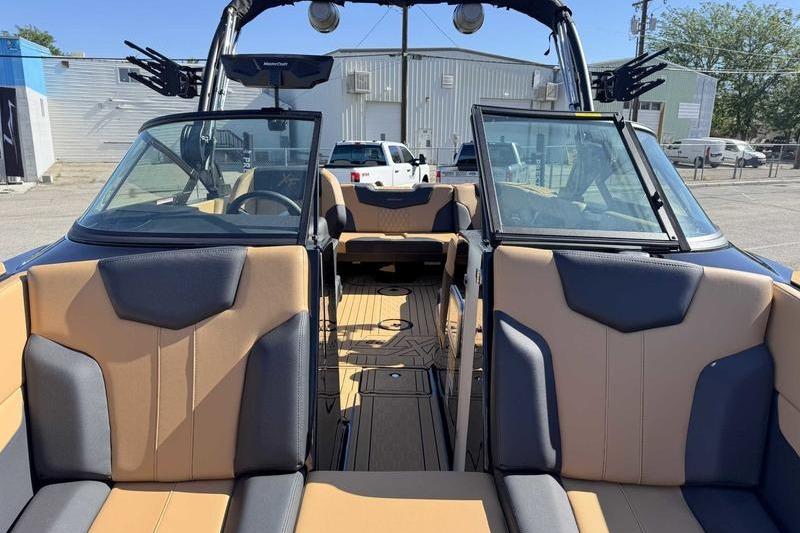 2026 MasterCraft XT22 boat interior with tan and gray seating, open windshield, and modern design.