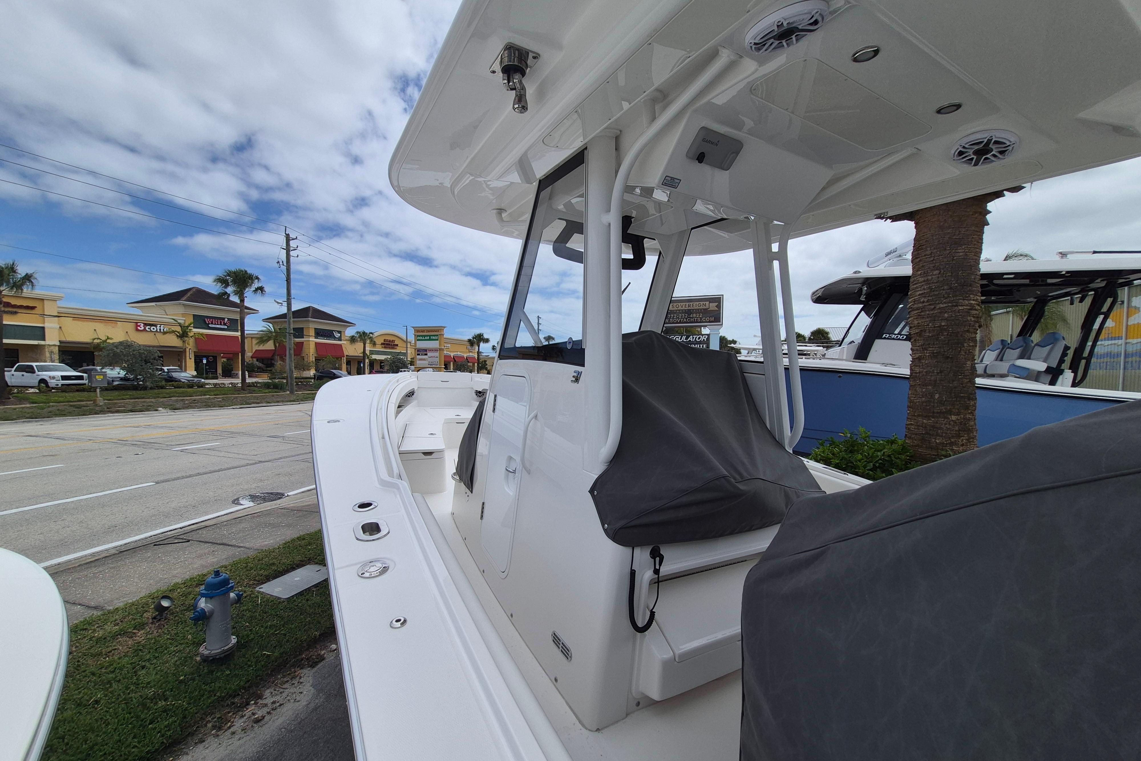 2026 Regulator 31 boat with covered seating, parked near a shopping center.