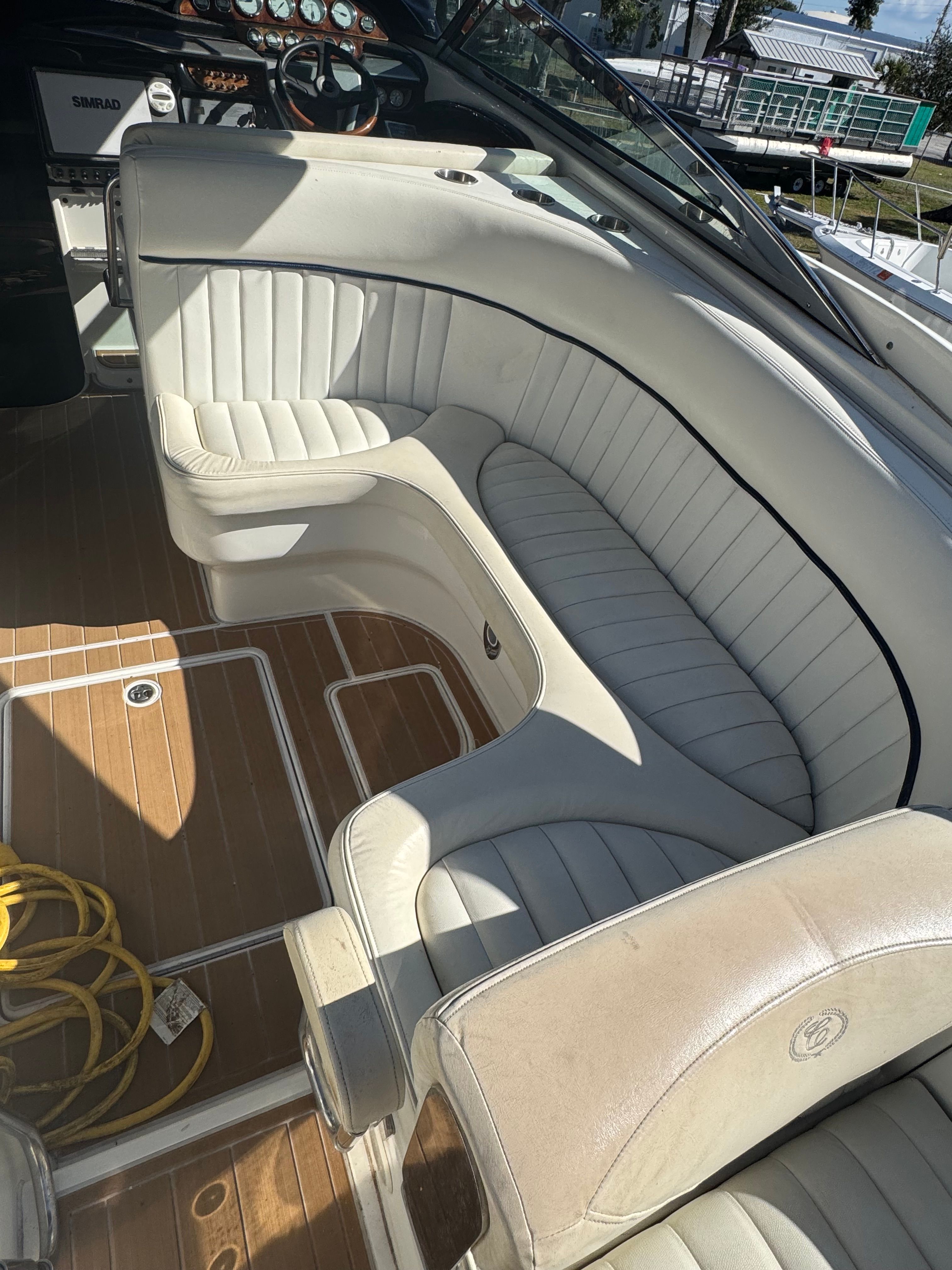 Interior view of a 2003 Cobalt 360 boat with white leather seating and wooden flooring.