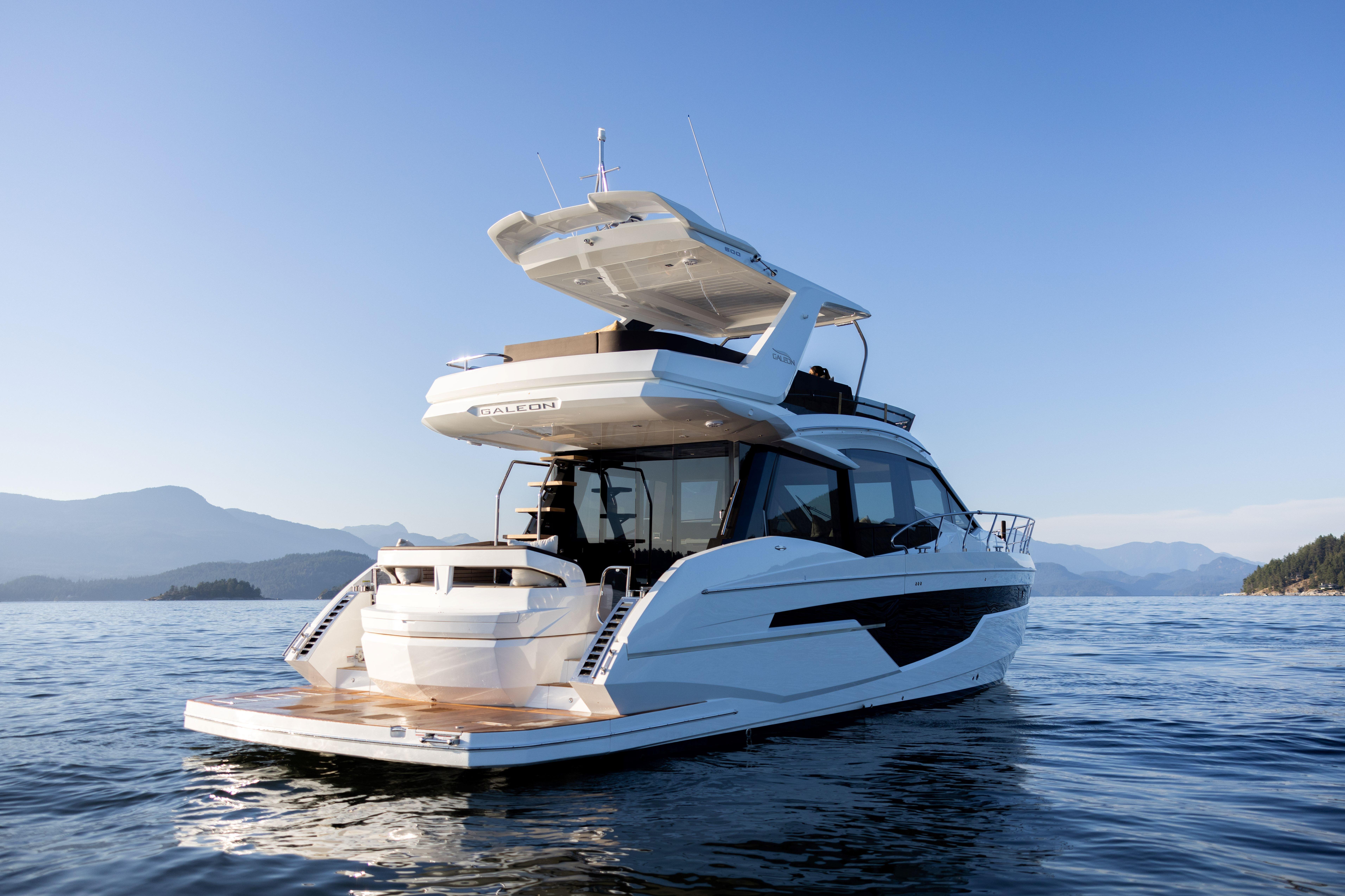 2026 Galeon 500 Fly yacht cruising on serene waters with scenic mountain backdrop.