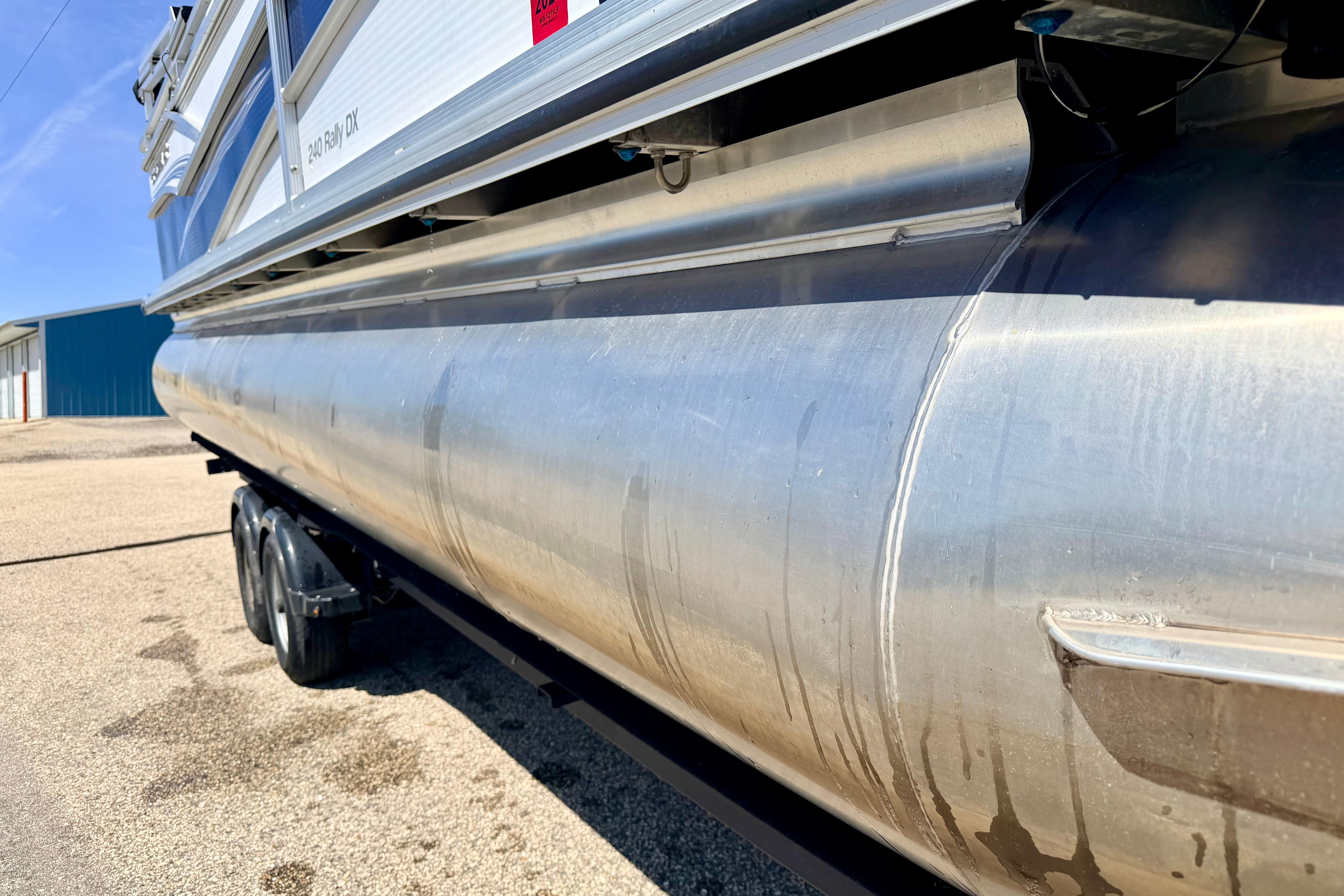 2019 Crestliner 240 Rally DX CW pontoon boat on trailer, side view.