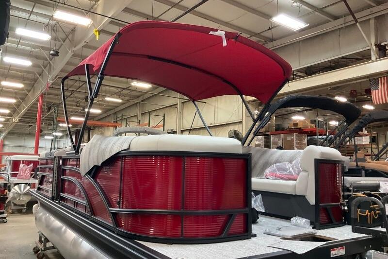 2026 Bennington 22 SSRSF pontoon boat with red canopy in a warehouse setting.