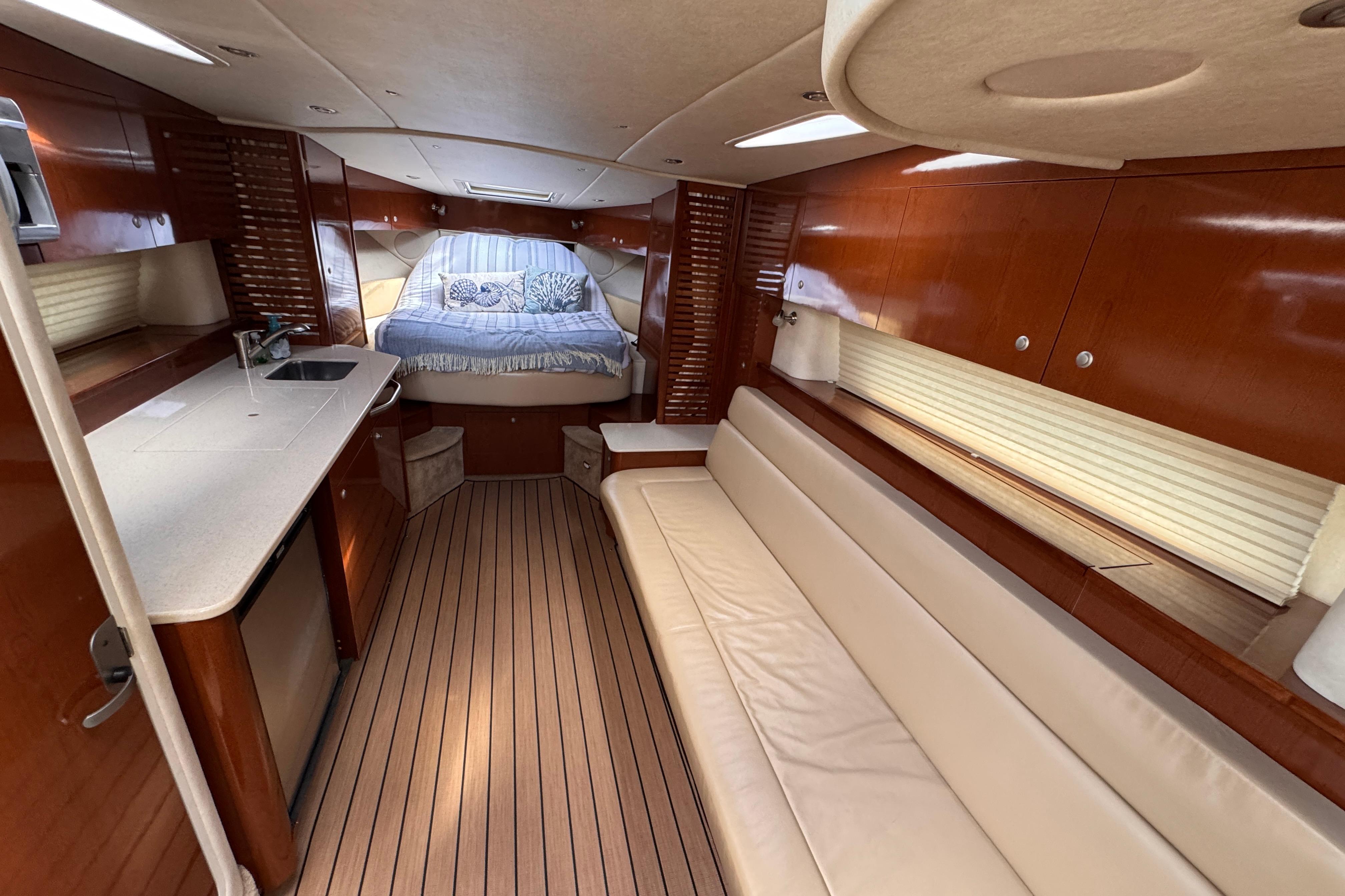 Luxurious interior of 2008 Sea Ray Sundancer 350 yacht with wood finishes and cozy seating.