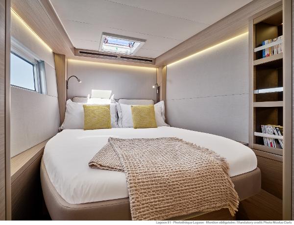 Luxurious bedroom interior of 2025 Lagoon 51 ICONIC yacht with cozy bedding and modern design.